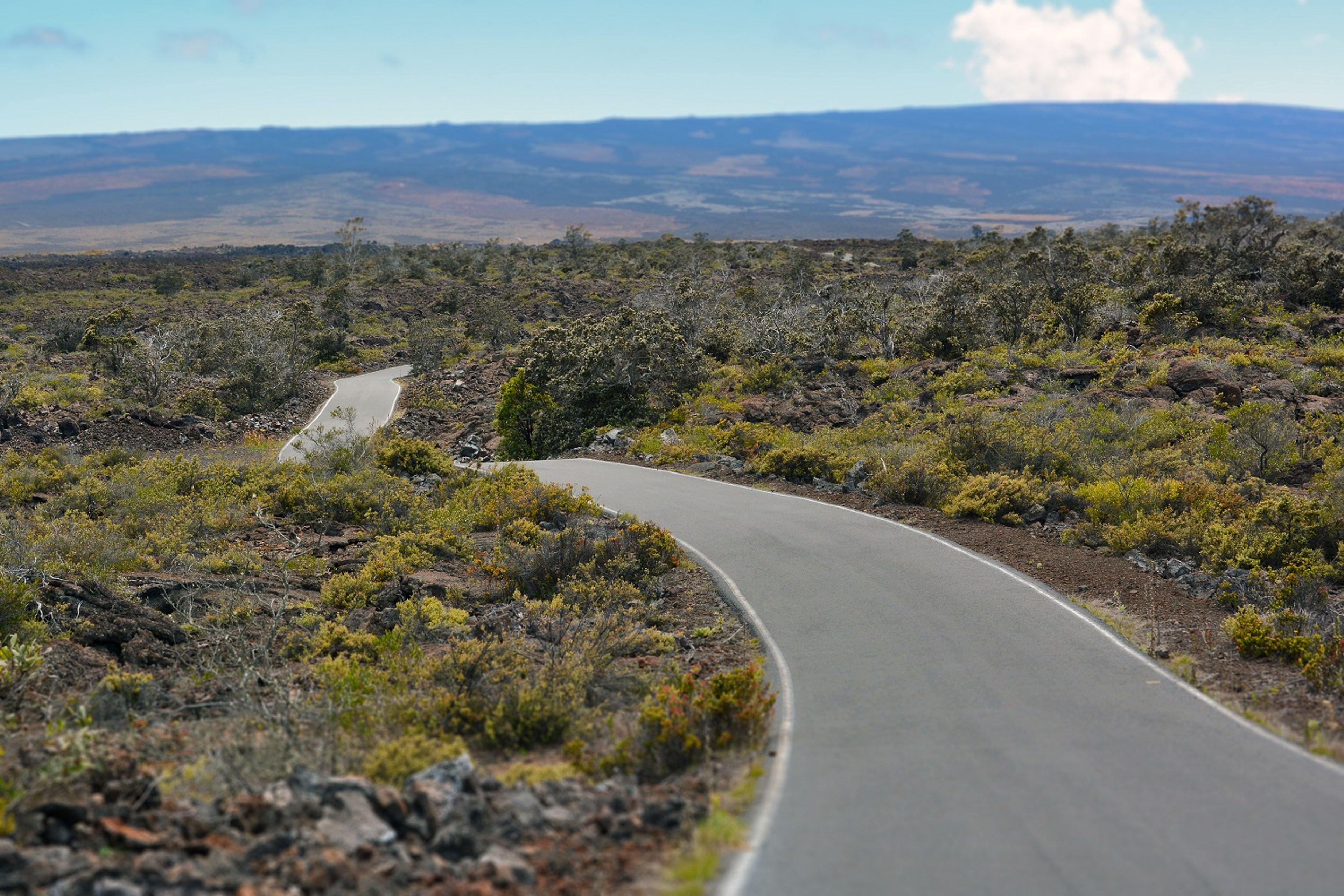 The road gradually ascends up the high-elevation slopes of Mauna Loa.