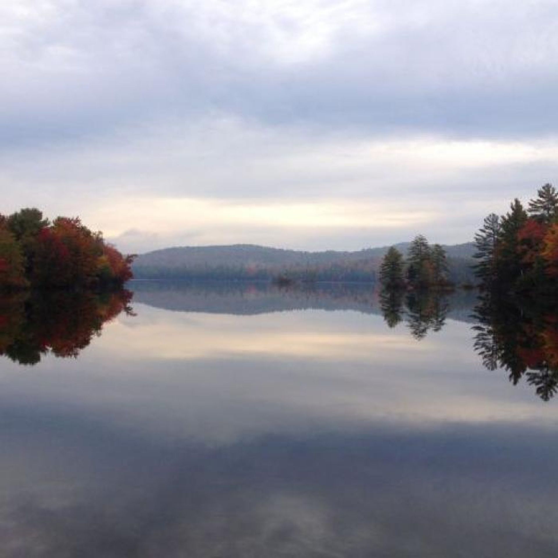 The mountains rise beyond the pond on an autumn day.