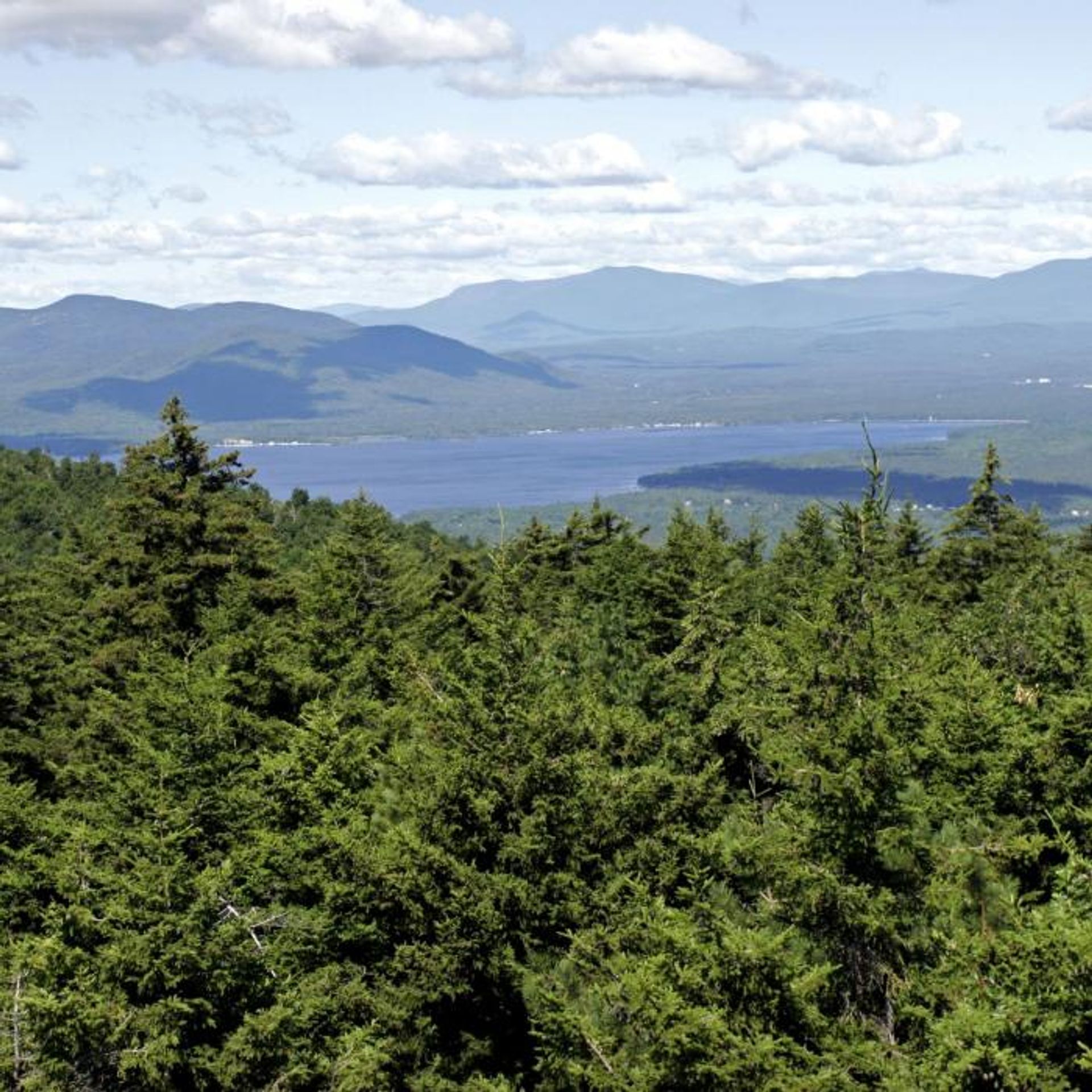 A view of a blue lake with mountains beyond.