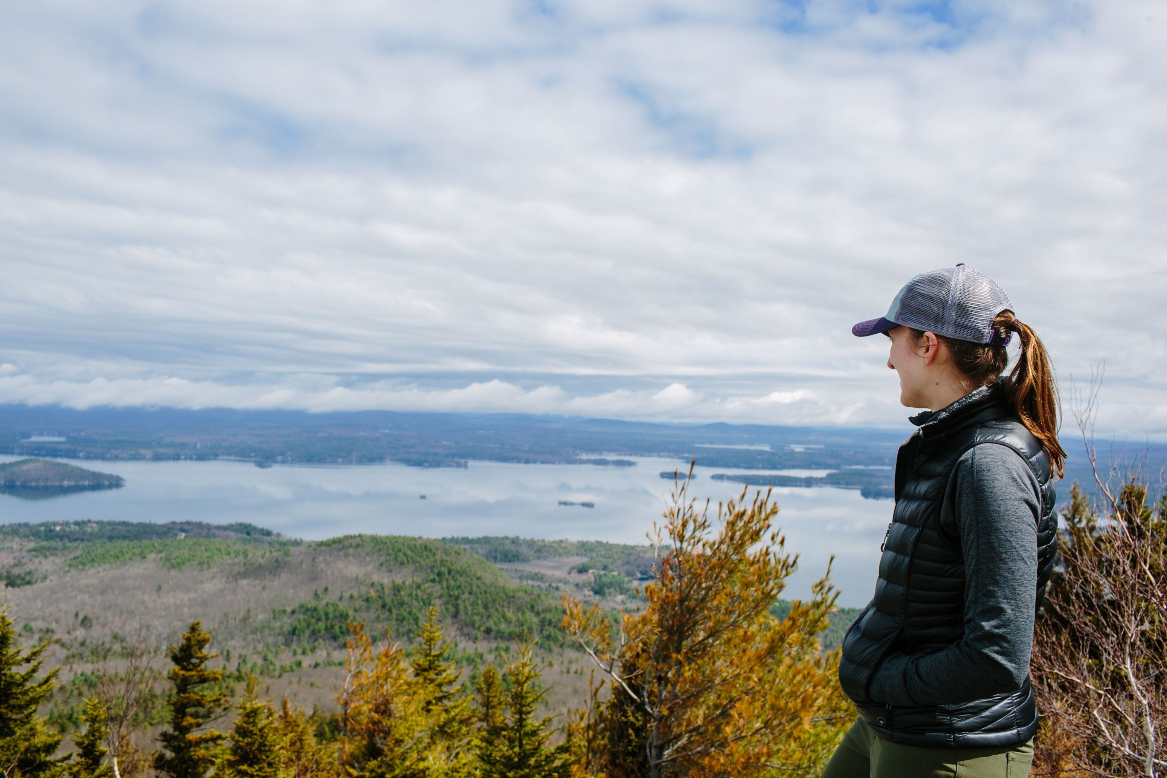 A hiker takes in the spring view from the summit of Mount Major.