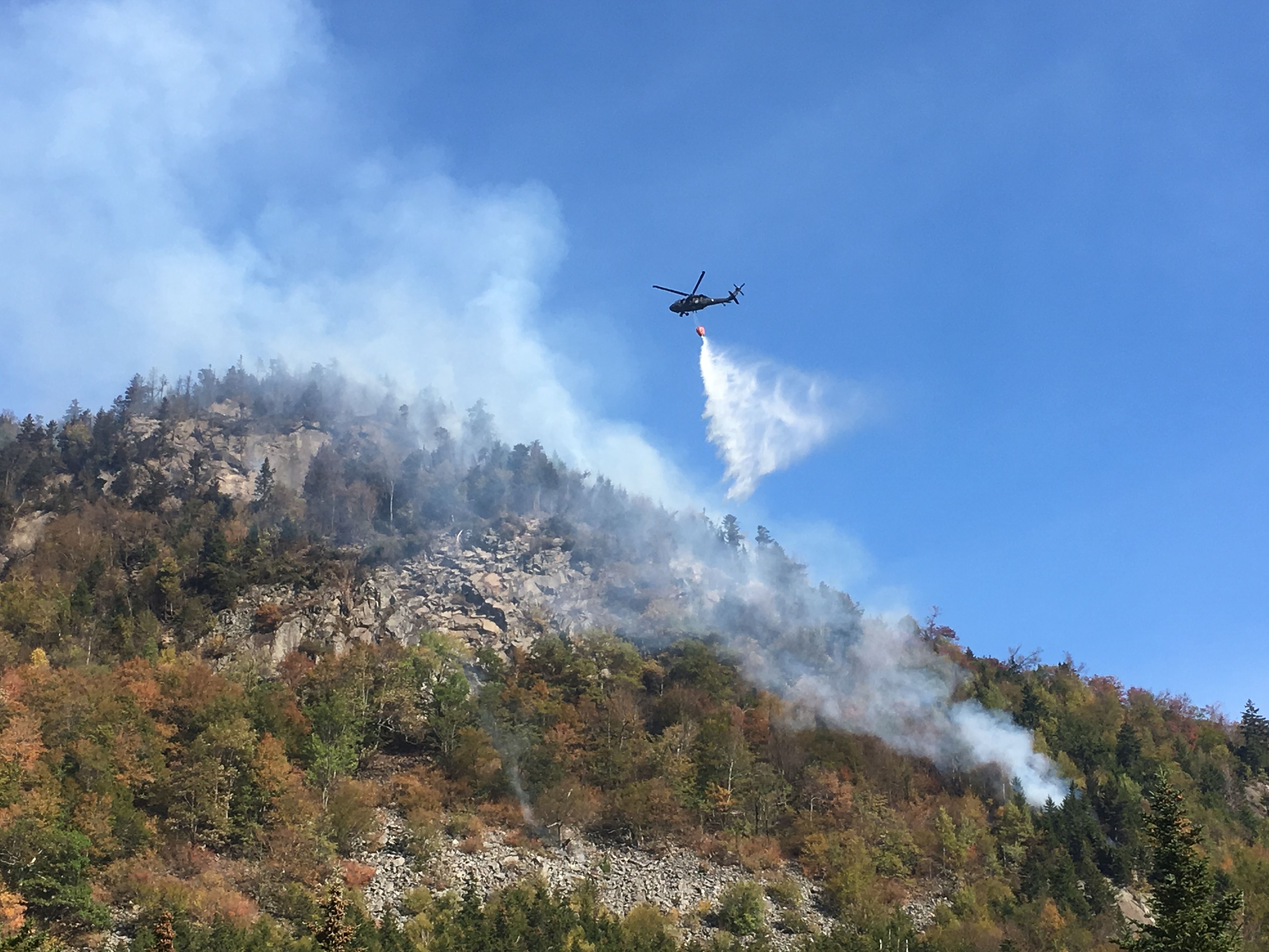 A NH National Guard helicopter drops water above the Dilly Cliff fire in October 2017.