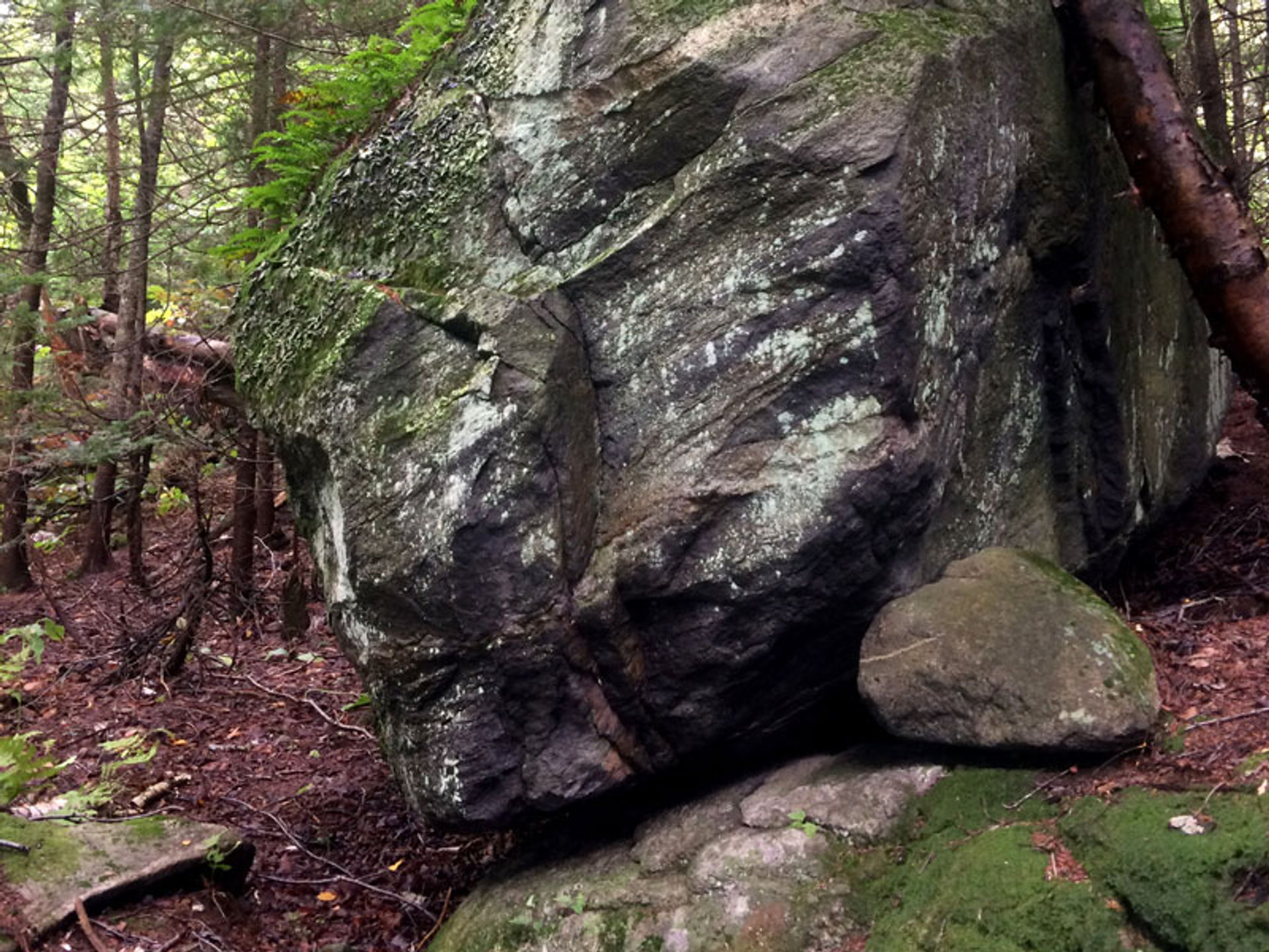 This boulder, a glacial erratic, appears balanced on the rock beneath.