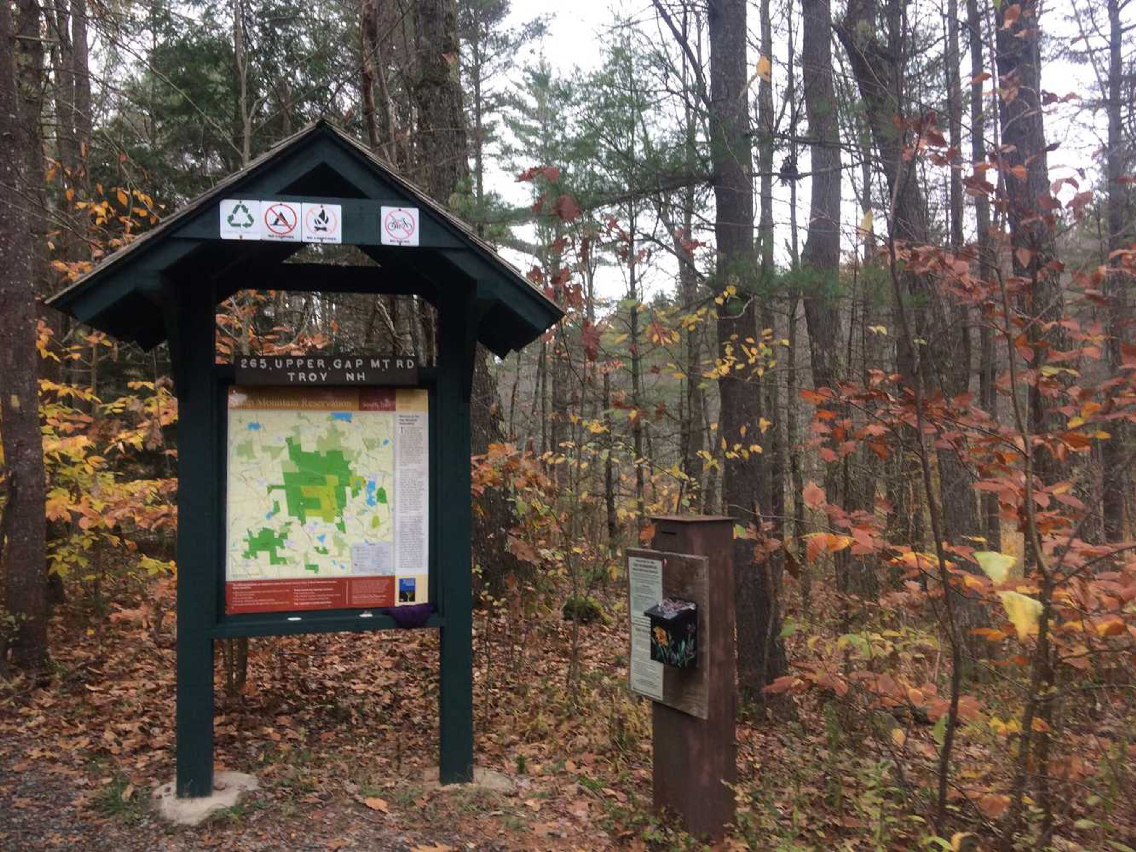 A kiosk with trail map and iron ranger (donation box).