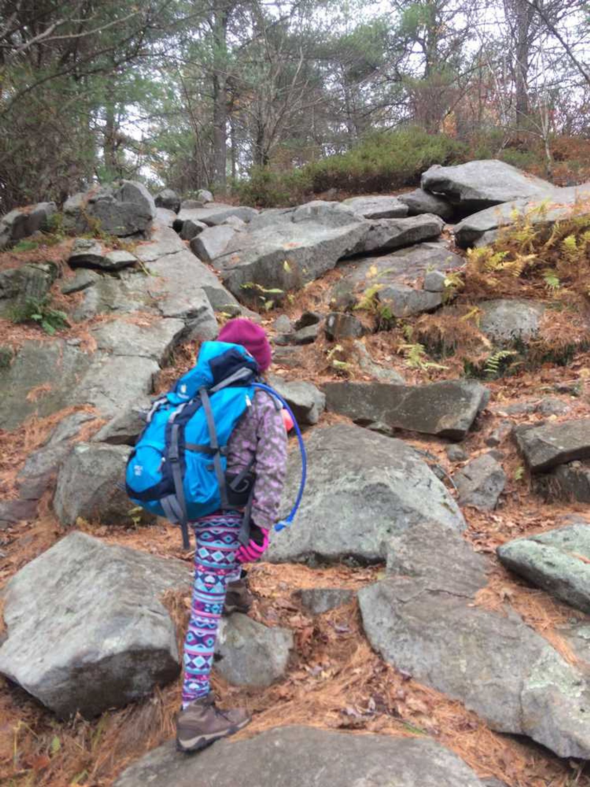 A girl walks a rocky trail.