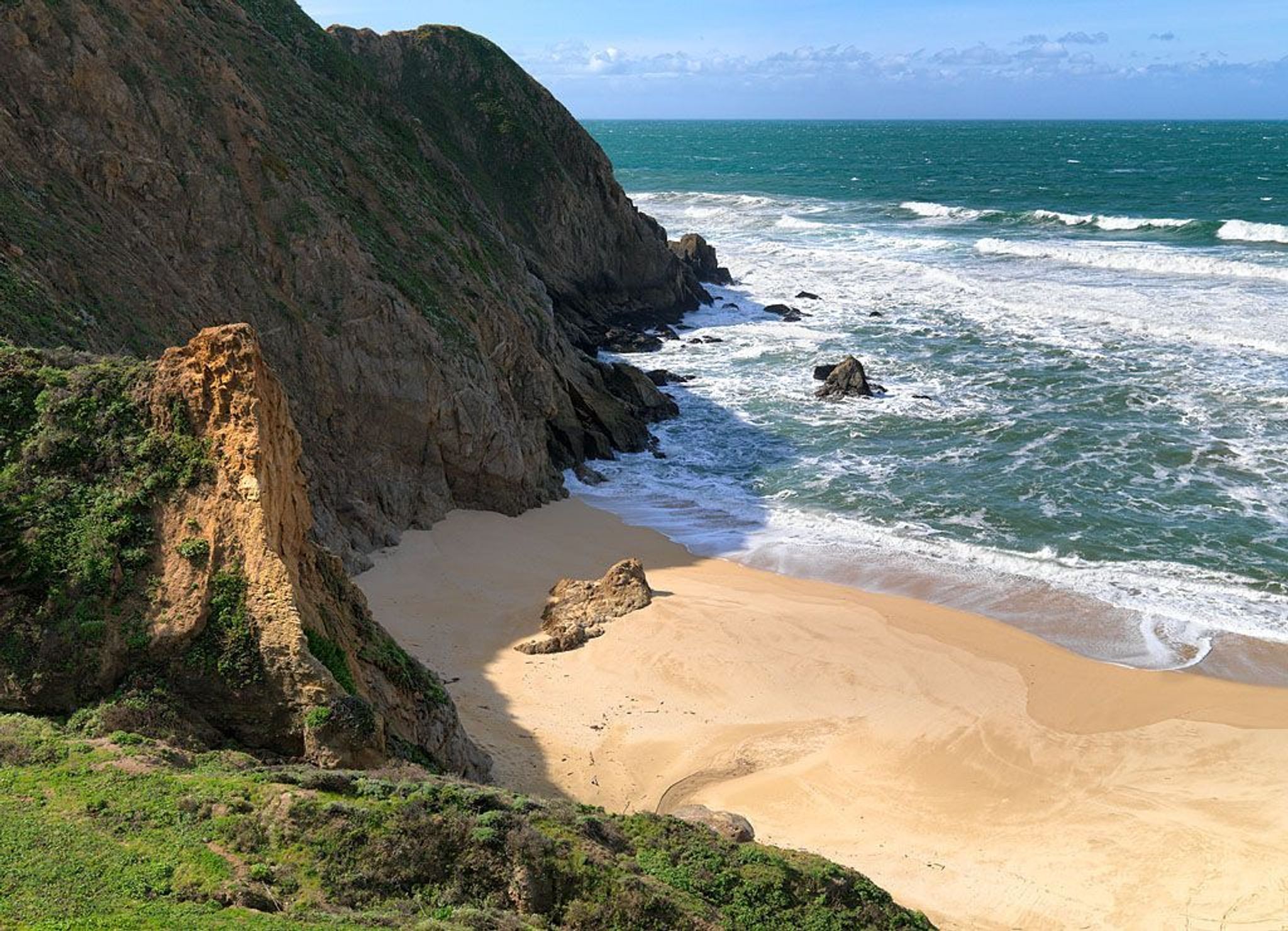 Beach and rocky cliffside. 