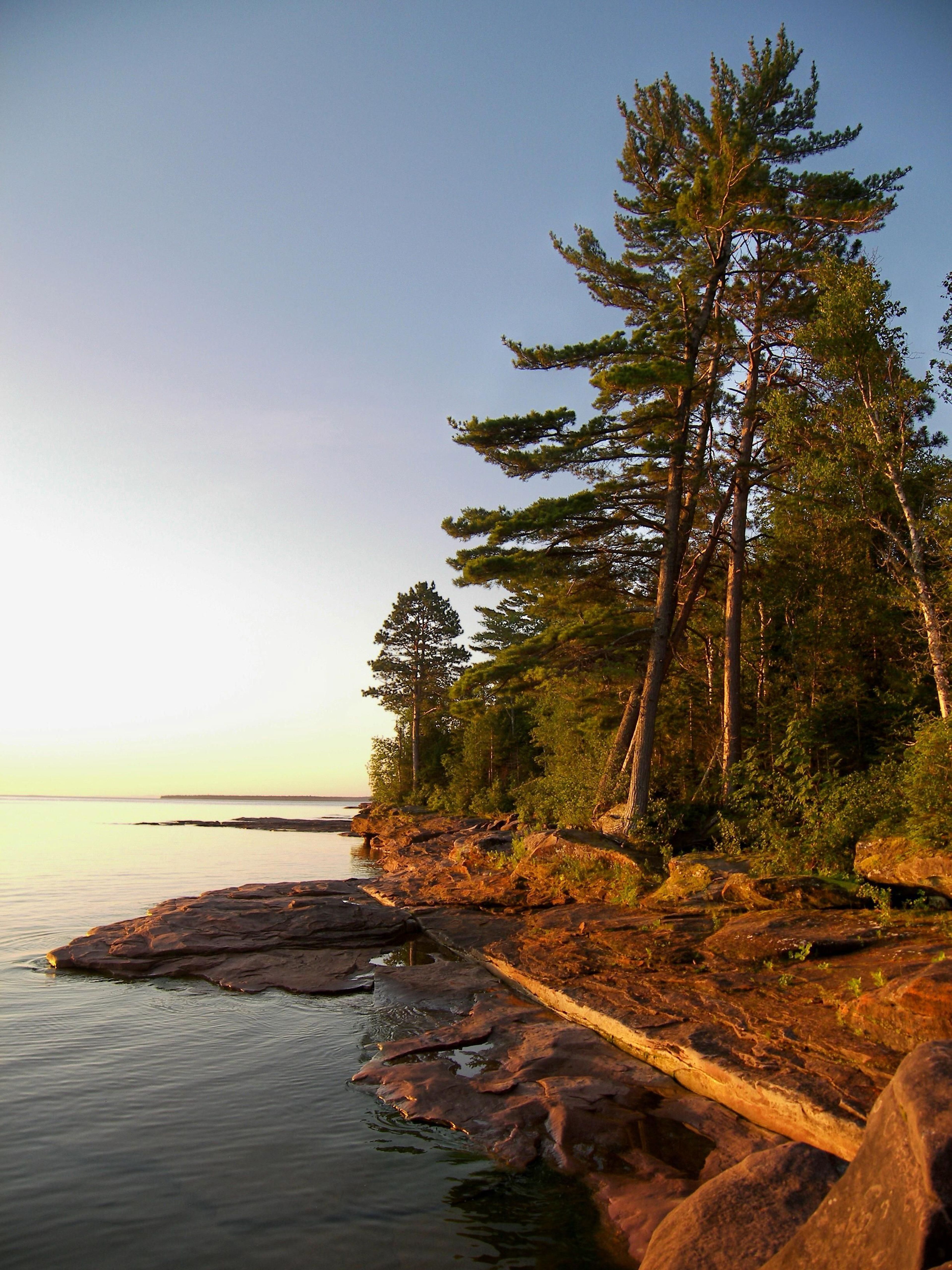 Experience the setting sun along a rocky island shoreline.