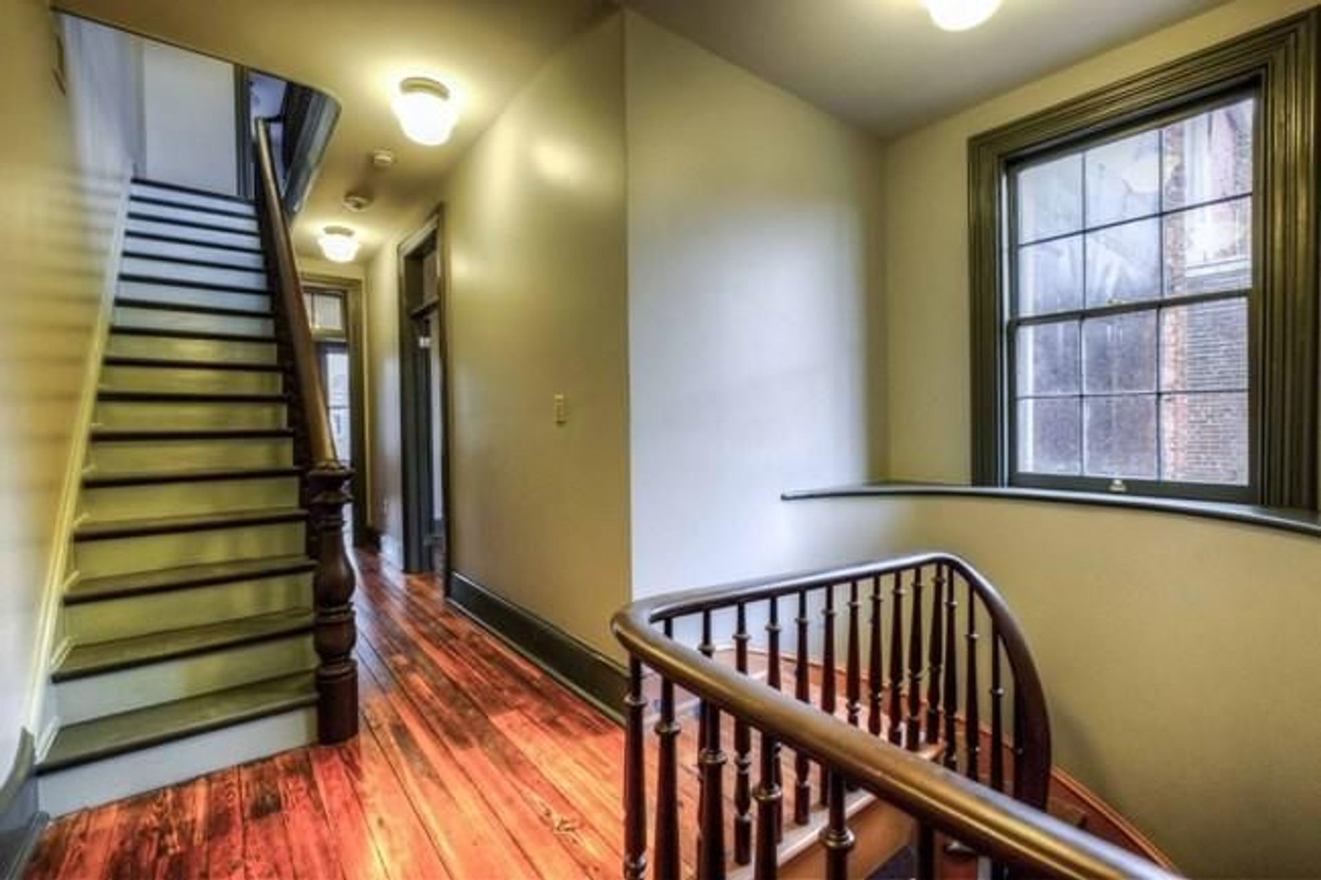 The second floor of the Woodson Home with restored original floorboards, steps, and railings.