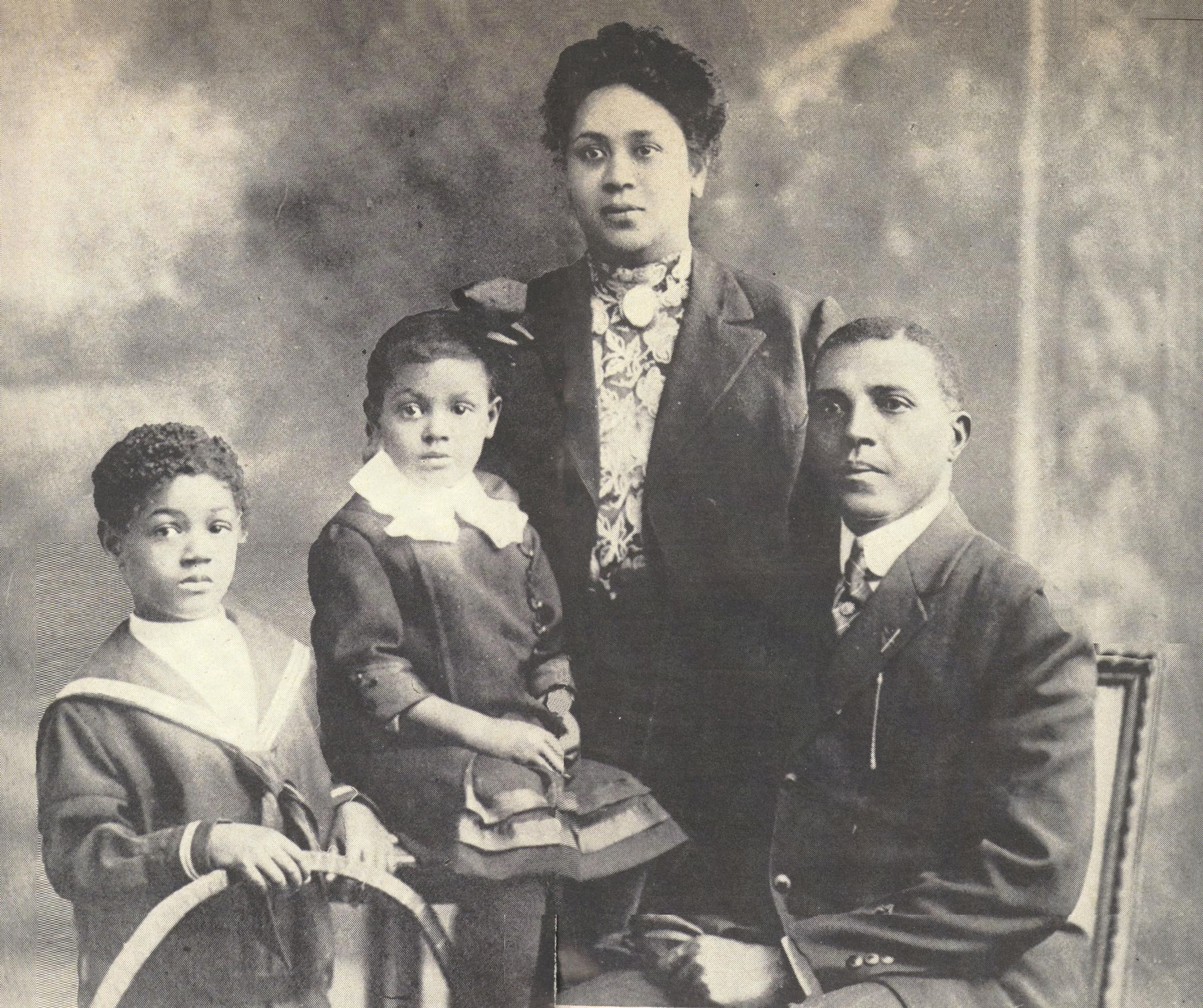 Charles Young (far right) poses with his family, Ada Young (standing rear), Charles Noel (far left), and Marie Aurelia (sitting middle).