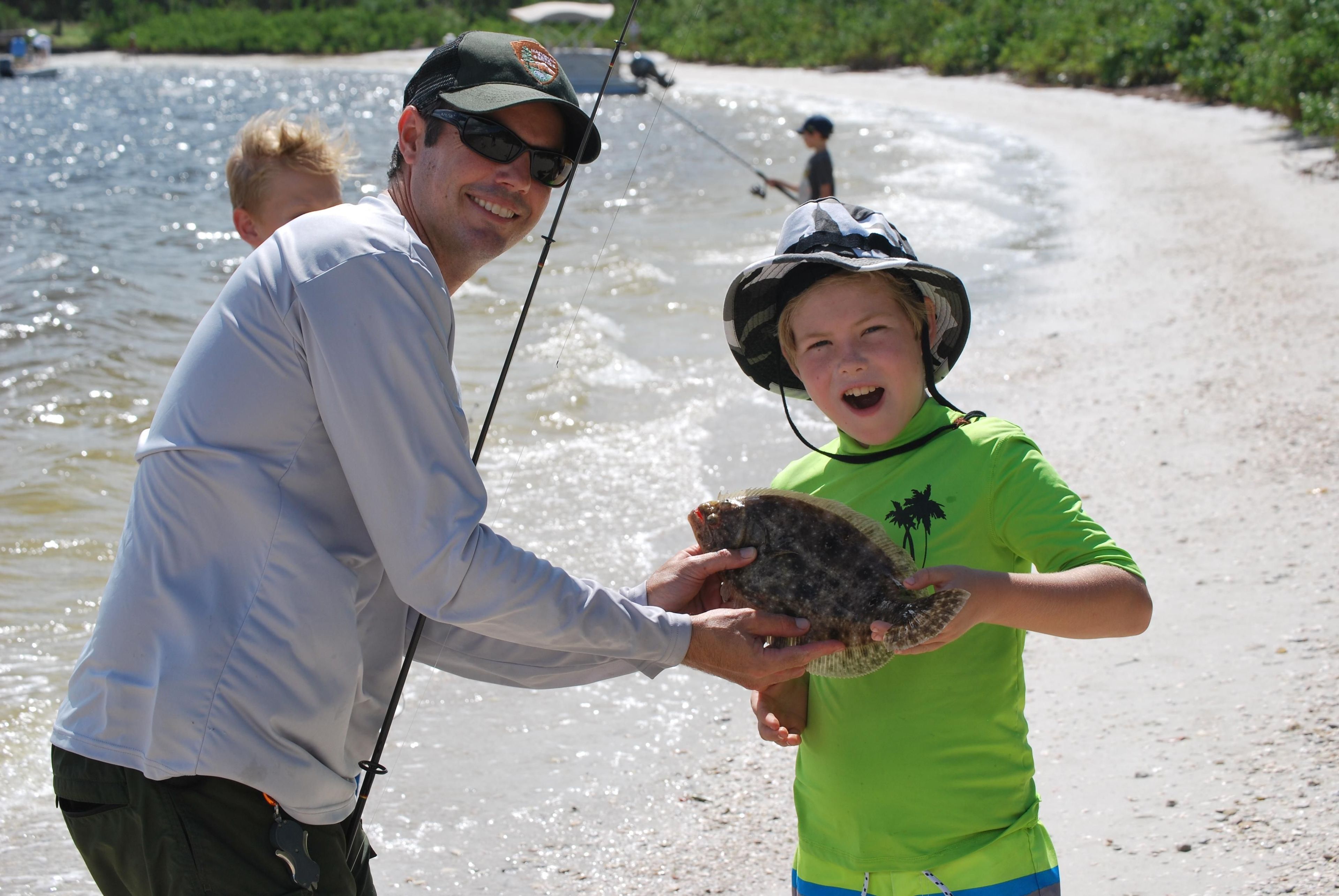 Superintendent Souder helps a young fisherman show off his catch at the De Soto Ranchero Fish Camp