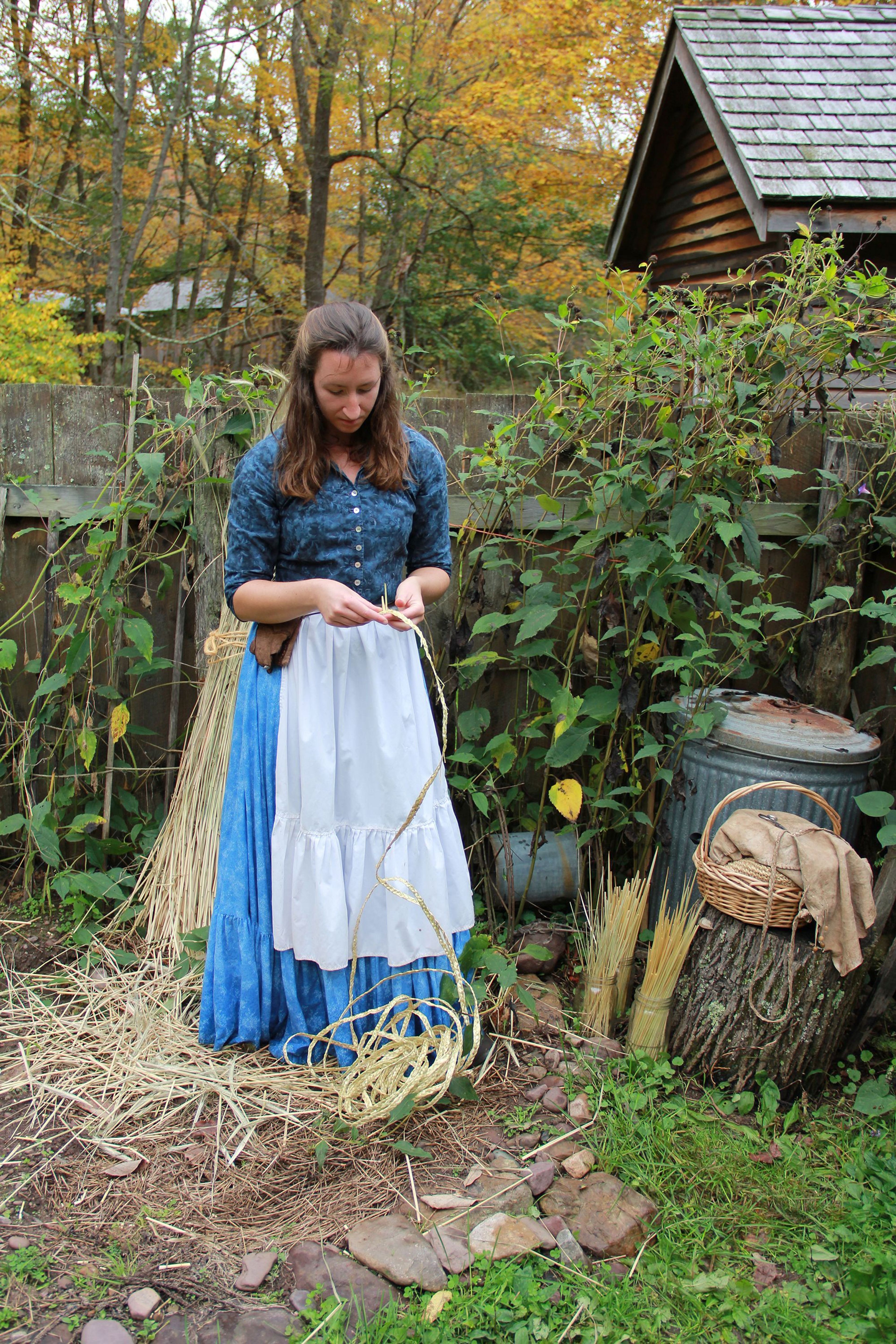 A woman braids rye straw for hatmaking