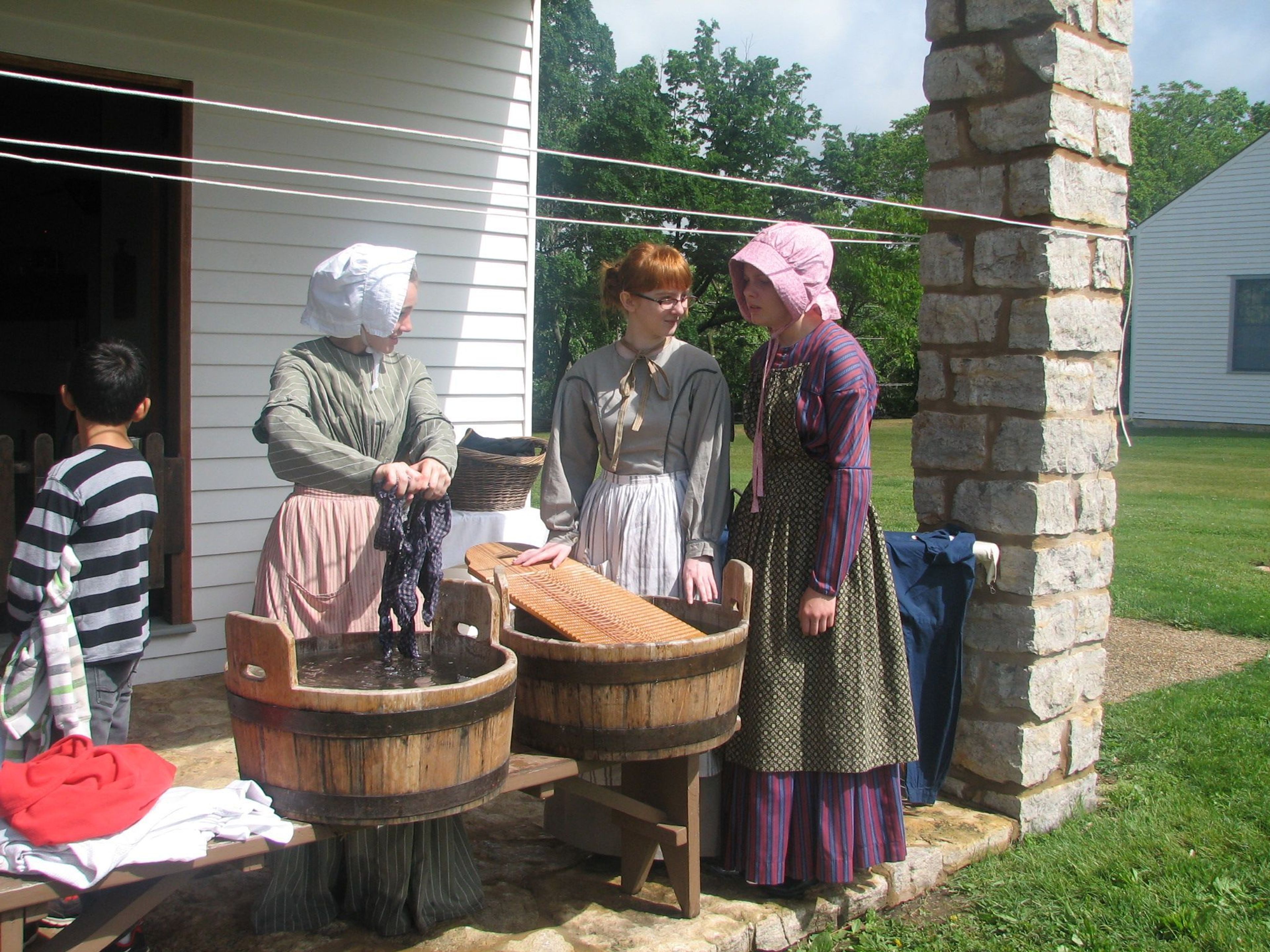 High school students dressed as laundresses demonstrate laundry methods of the 1840s