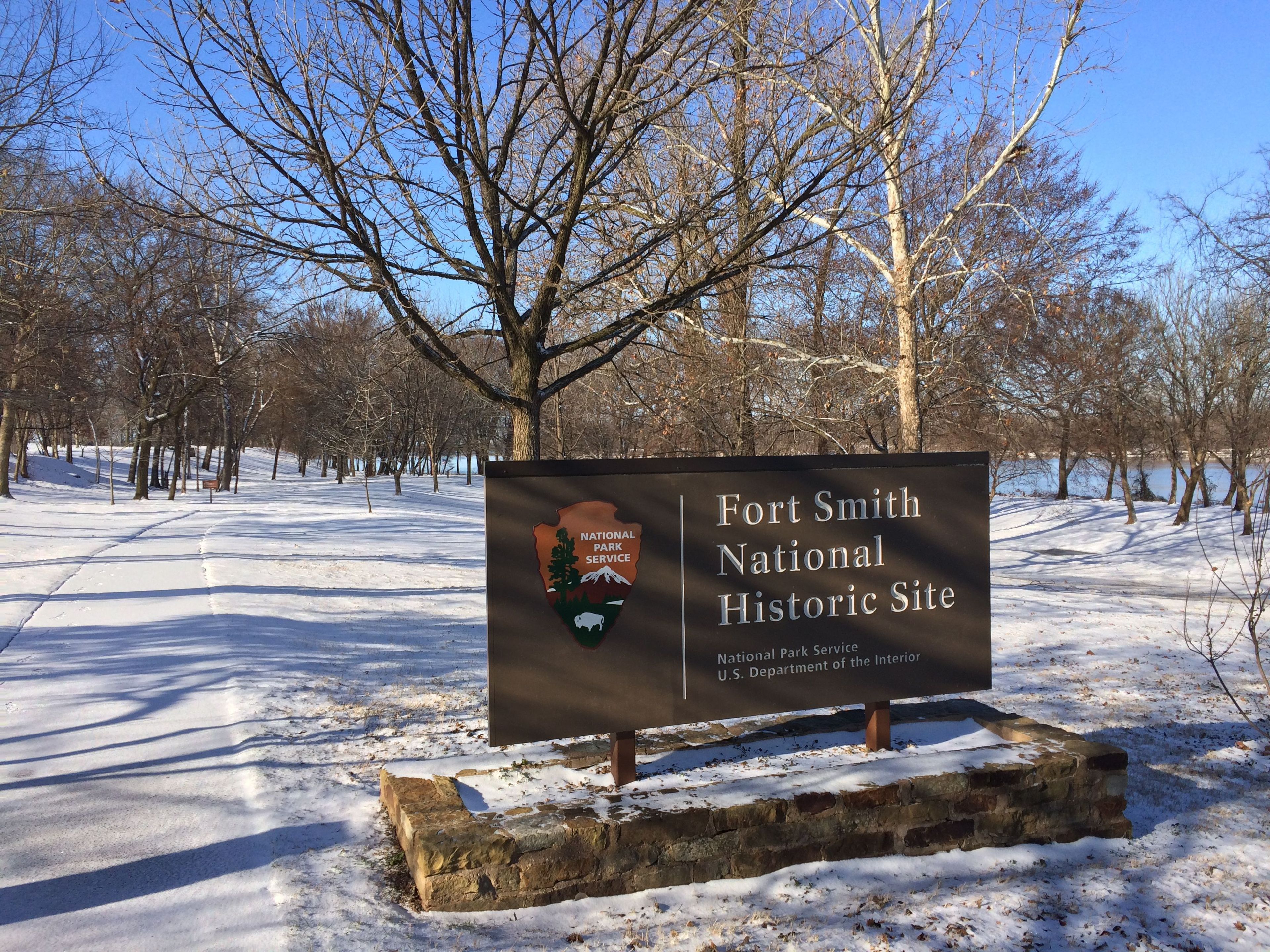 Entrance sign along the river trail on a snowy day.