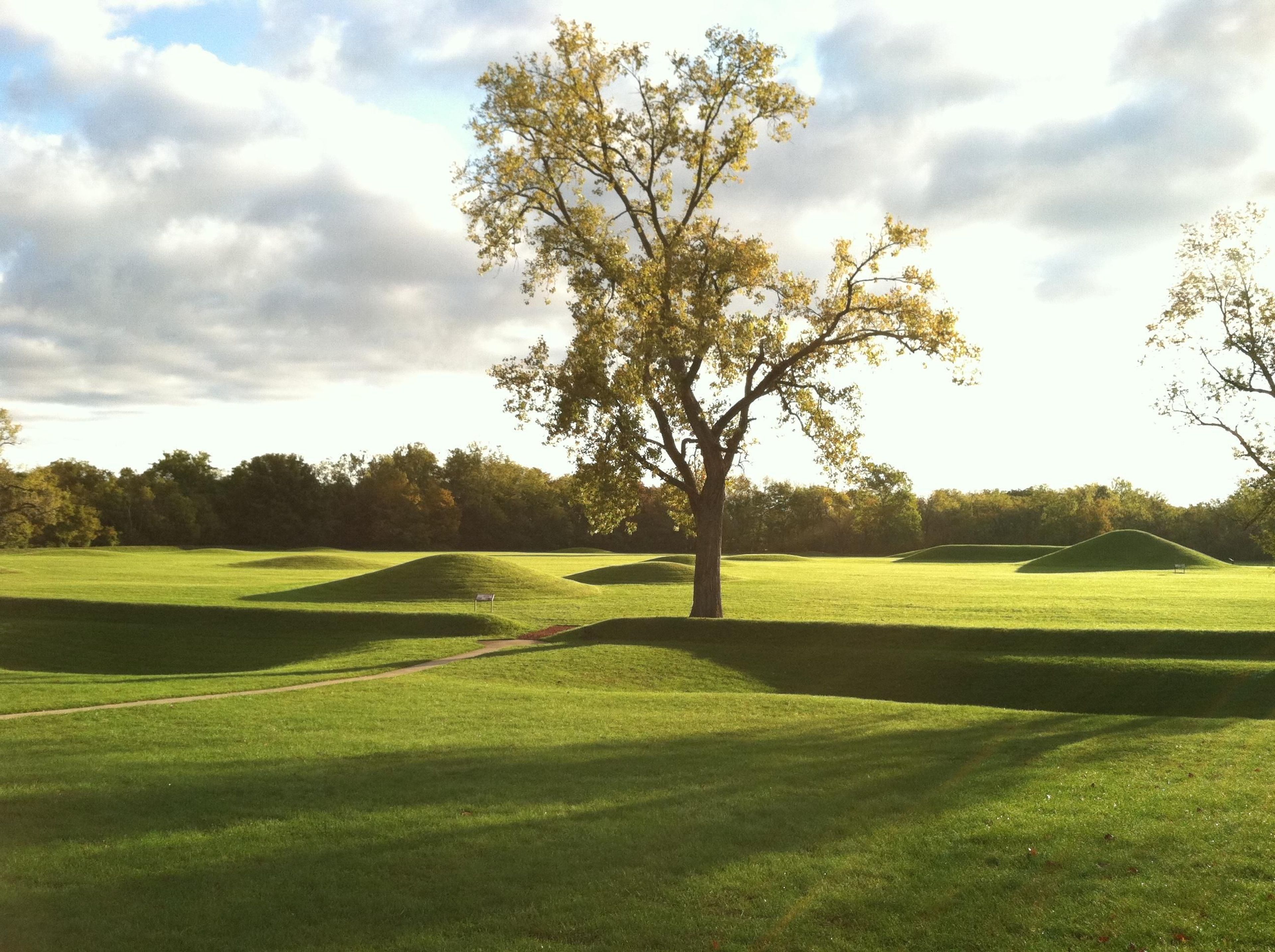 Dawn at the Mound City Group as the sun casts long shadows over the grass.