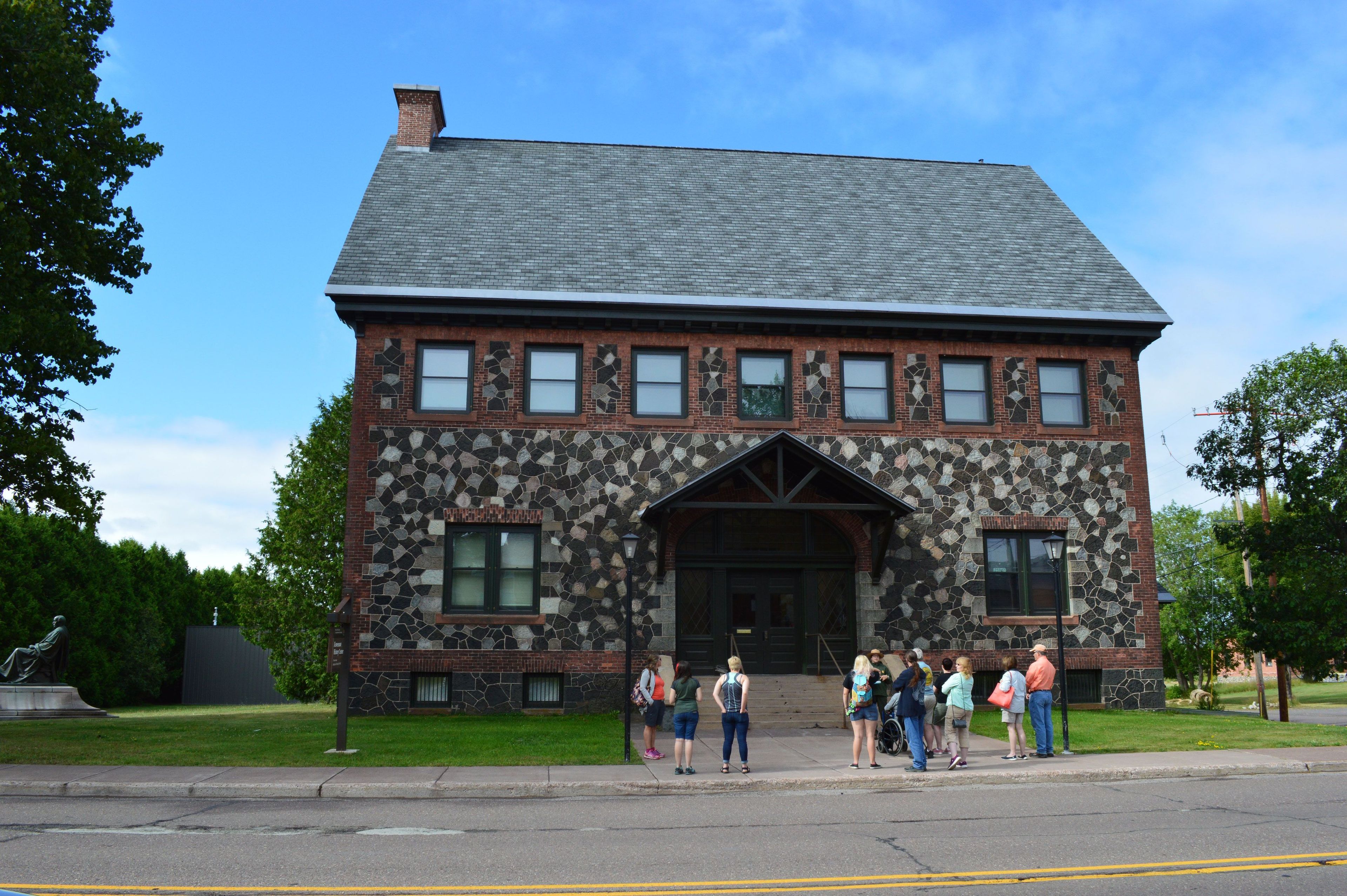 A ranger guided walk outside the former Calumet & Hecla Public Library, now known at the Keweenaw History Center.