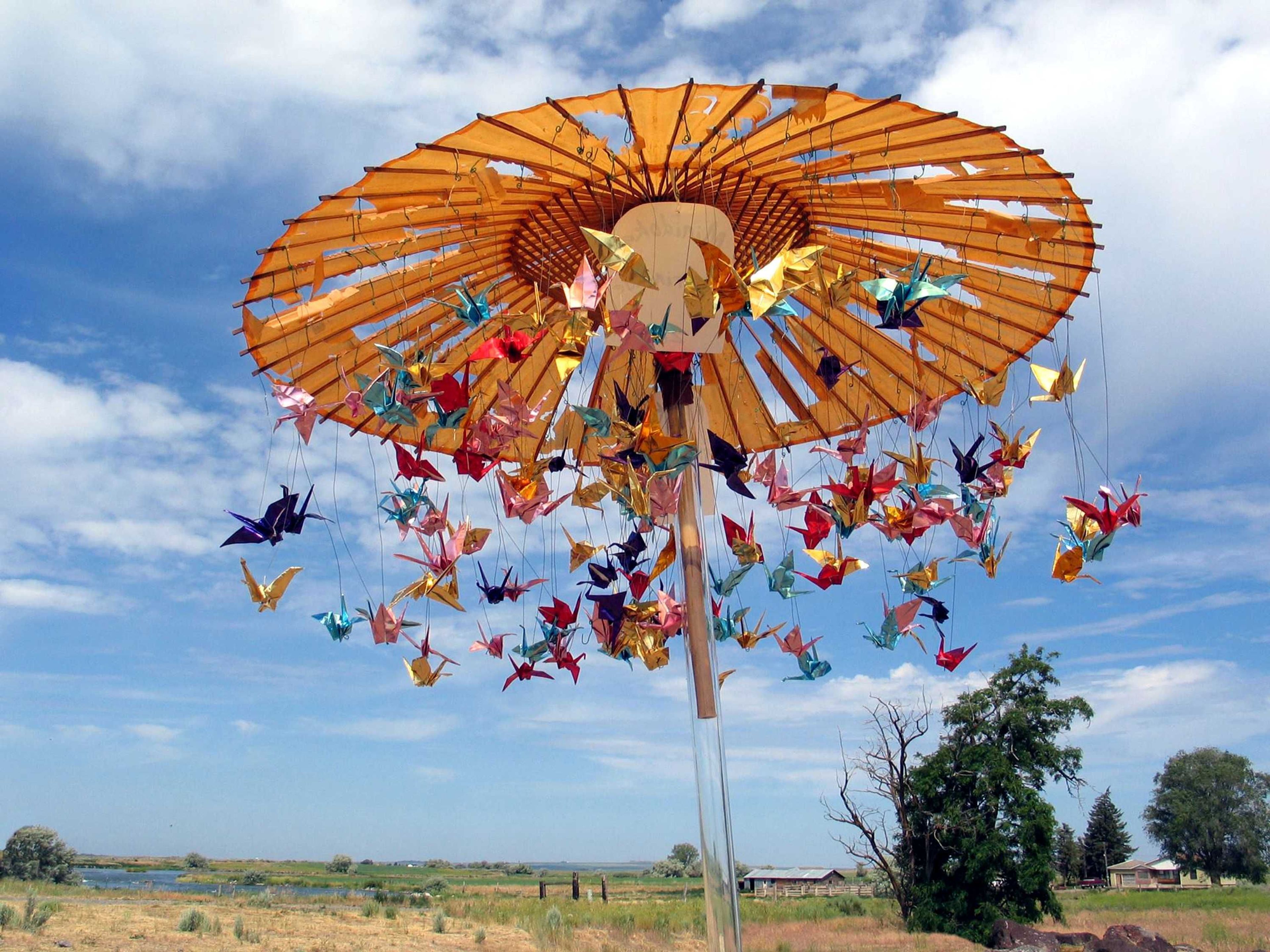 Origami cranes twirl on a colorful carousel.