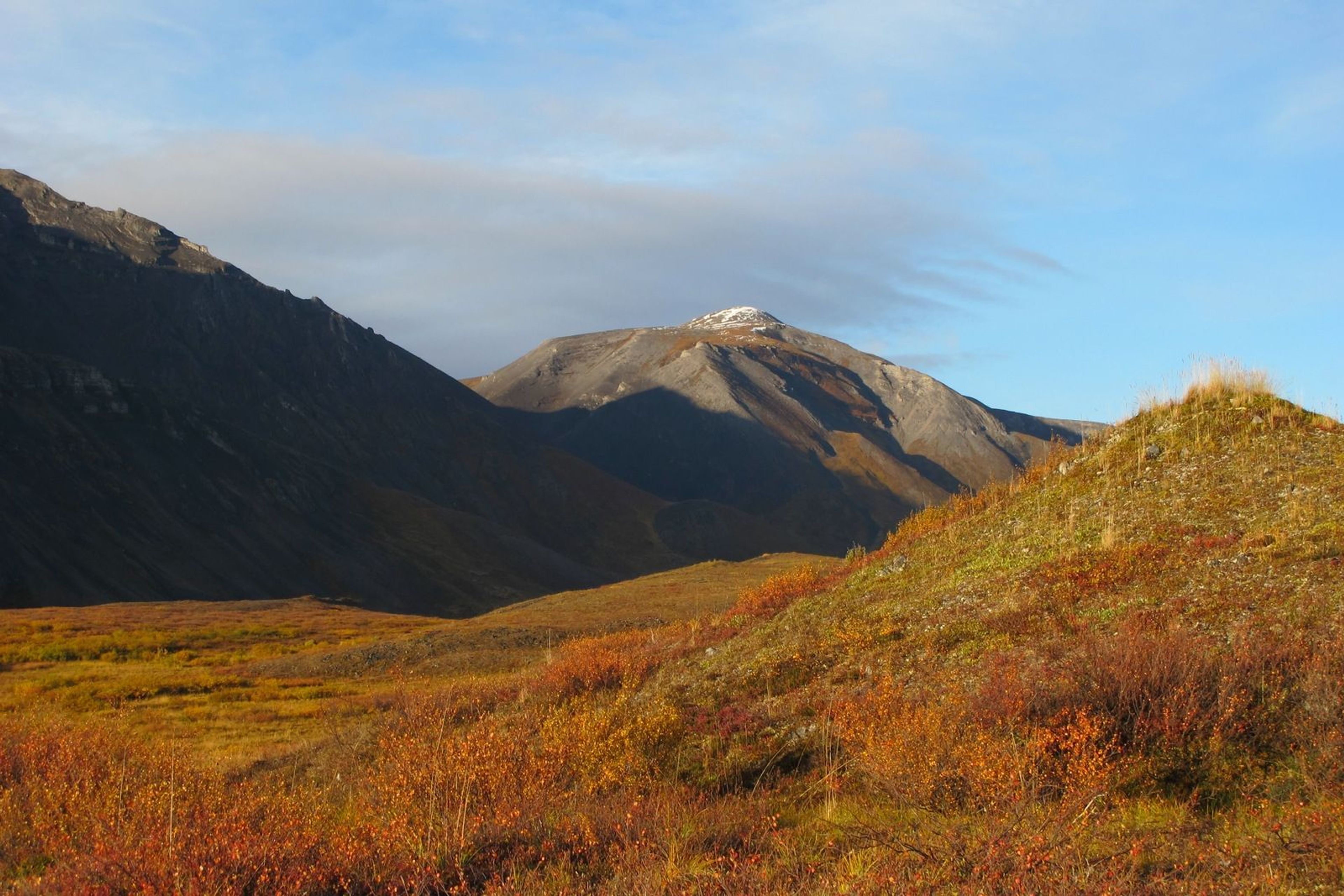 The famous golden hour near sunset on Copter Peak gives depth to the mountains and neon hues to the tundra.