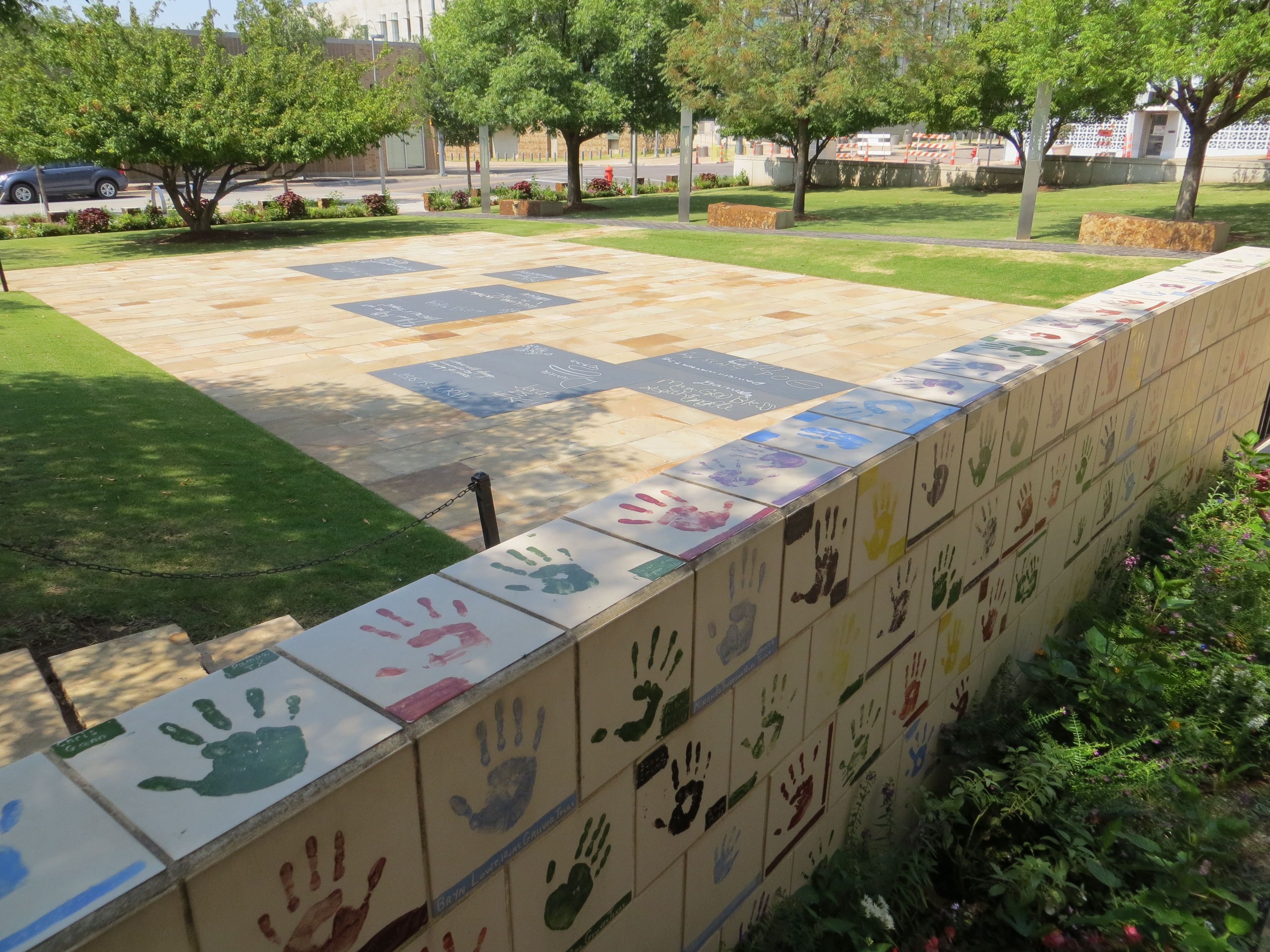 This area provides letter shaped chalkboards to allow the continued emotional expressions from those young and old. A surrounding wall displays a collection of painted tiles sent by schools, showing their compassion for the bombing-affected community