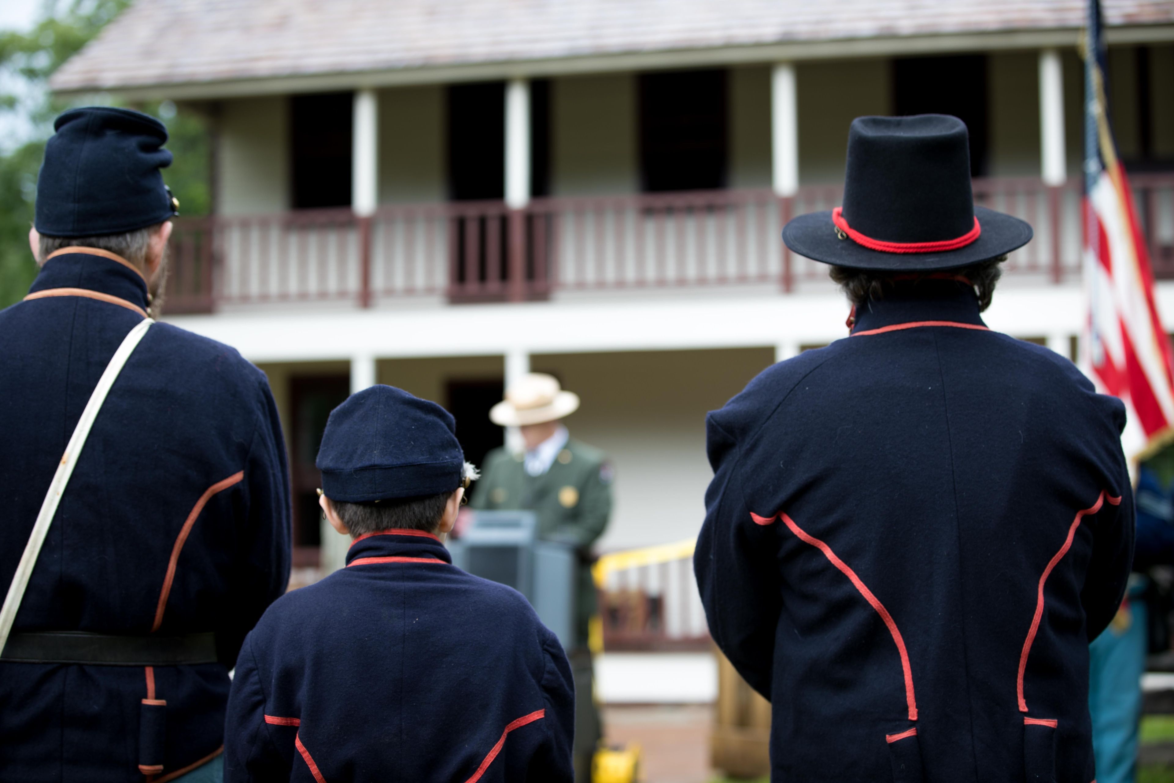 Photo of Union Union artilleryman reenactors standing in front of the Elkhorn Tavern for the rededication of the building.