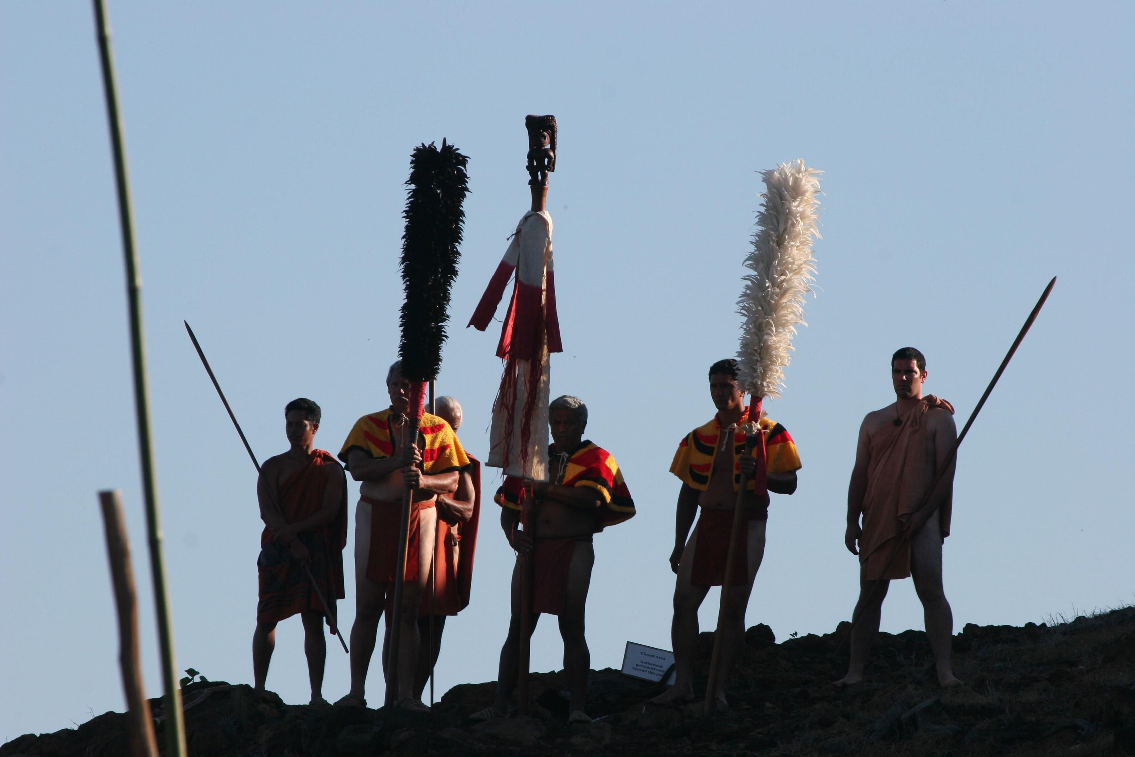 Warriors dressed in traditional attire presenting war god Kū on top of Pu'ukoholā Heiau during Ho'oku'ikahi Ceremony.