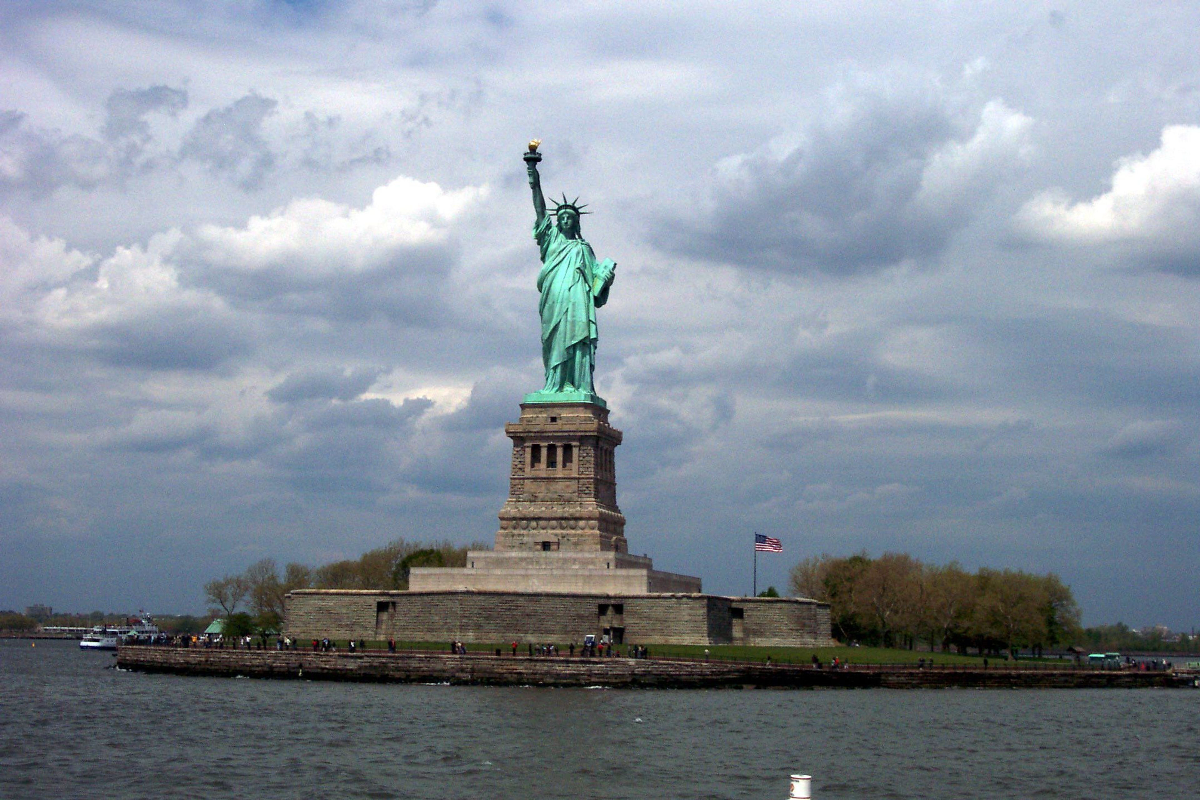 The Statue of Liberty's patina green stands out brilliantly on a cloudy day.