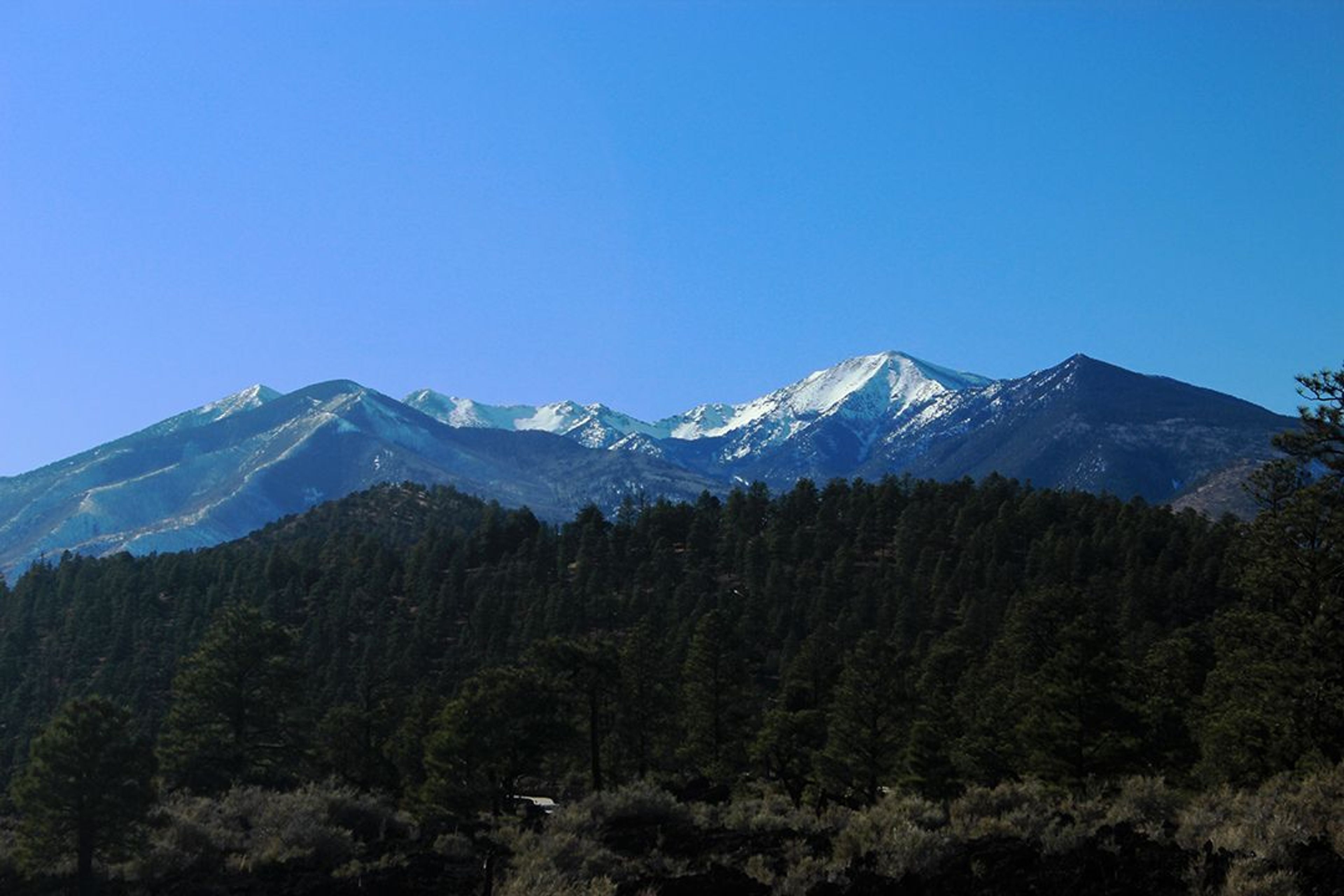 Sunset Crater Volcano is the most recent eruption in the San Francisco volcanic field. Visitors can climb Lenox Crater, foreground, for excellent views of the field, including the San Francisco Peaks.