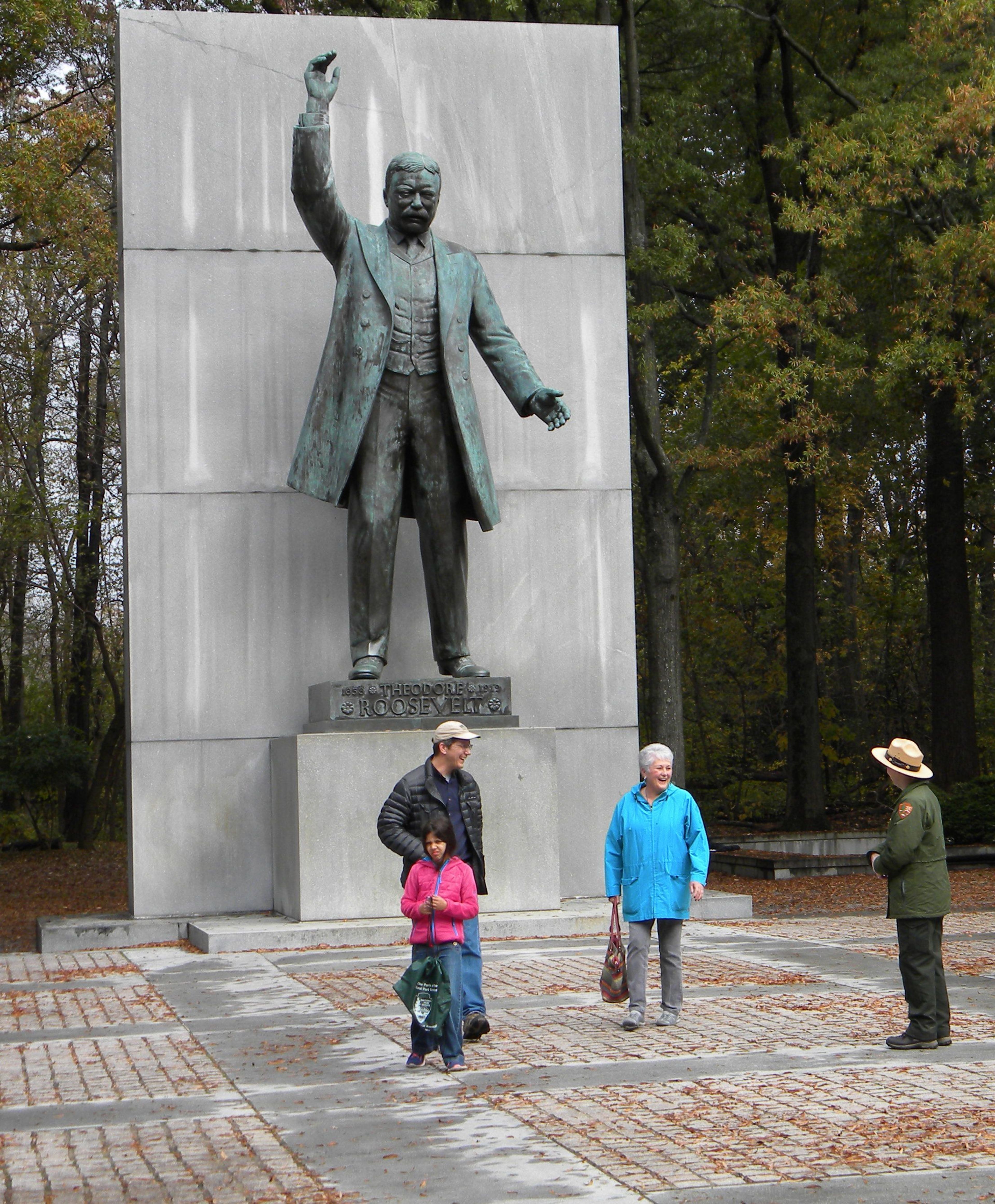 National Park Service Ranger discussing Theodore Roosevelt with visitors at his memorial.