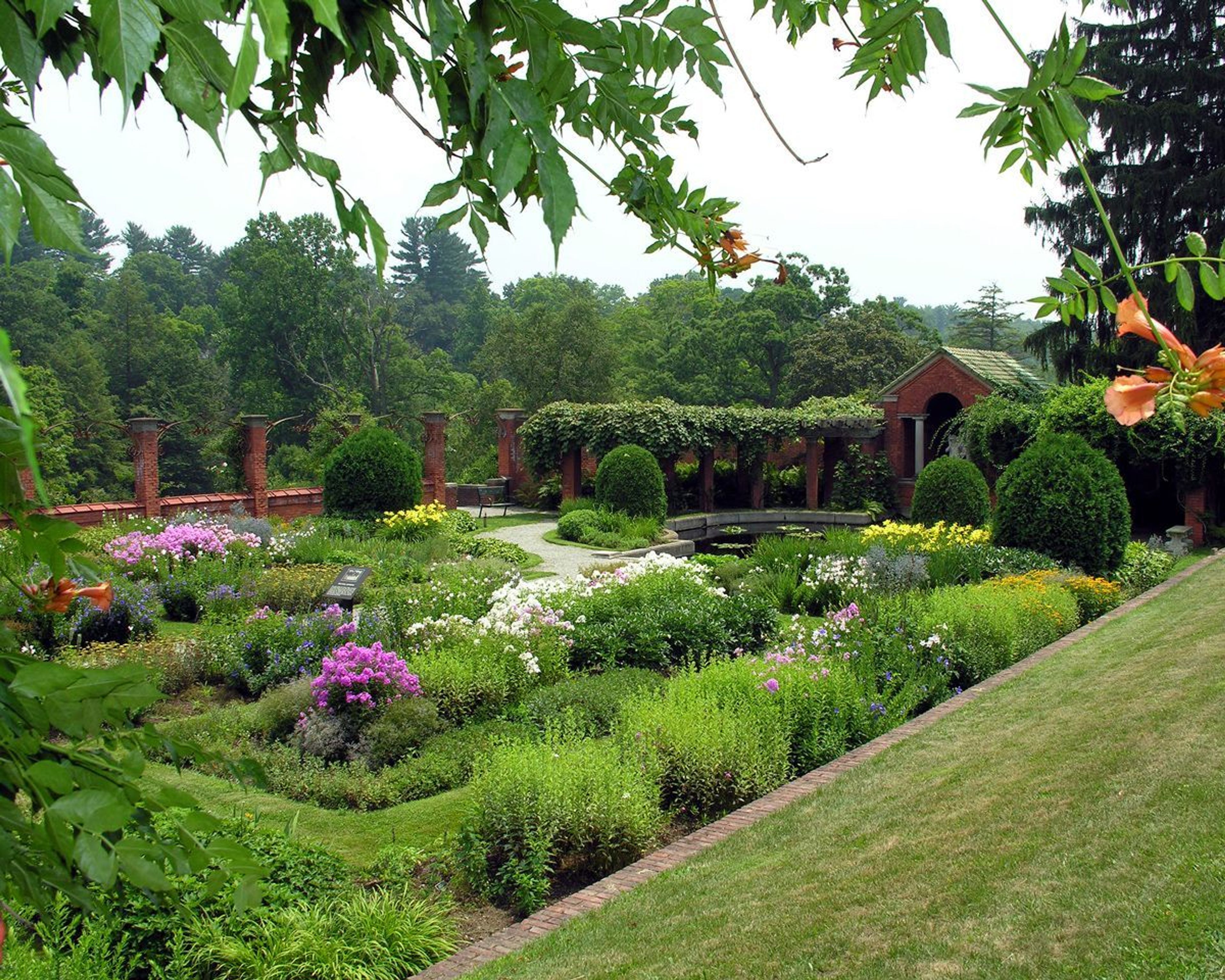 The formal gardens of the Vanderbilt Estate consist of multiple tiers defined over a hillside, surrounded by a graceful landscape.