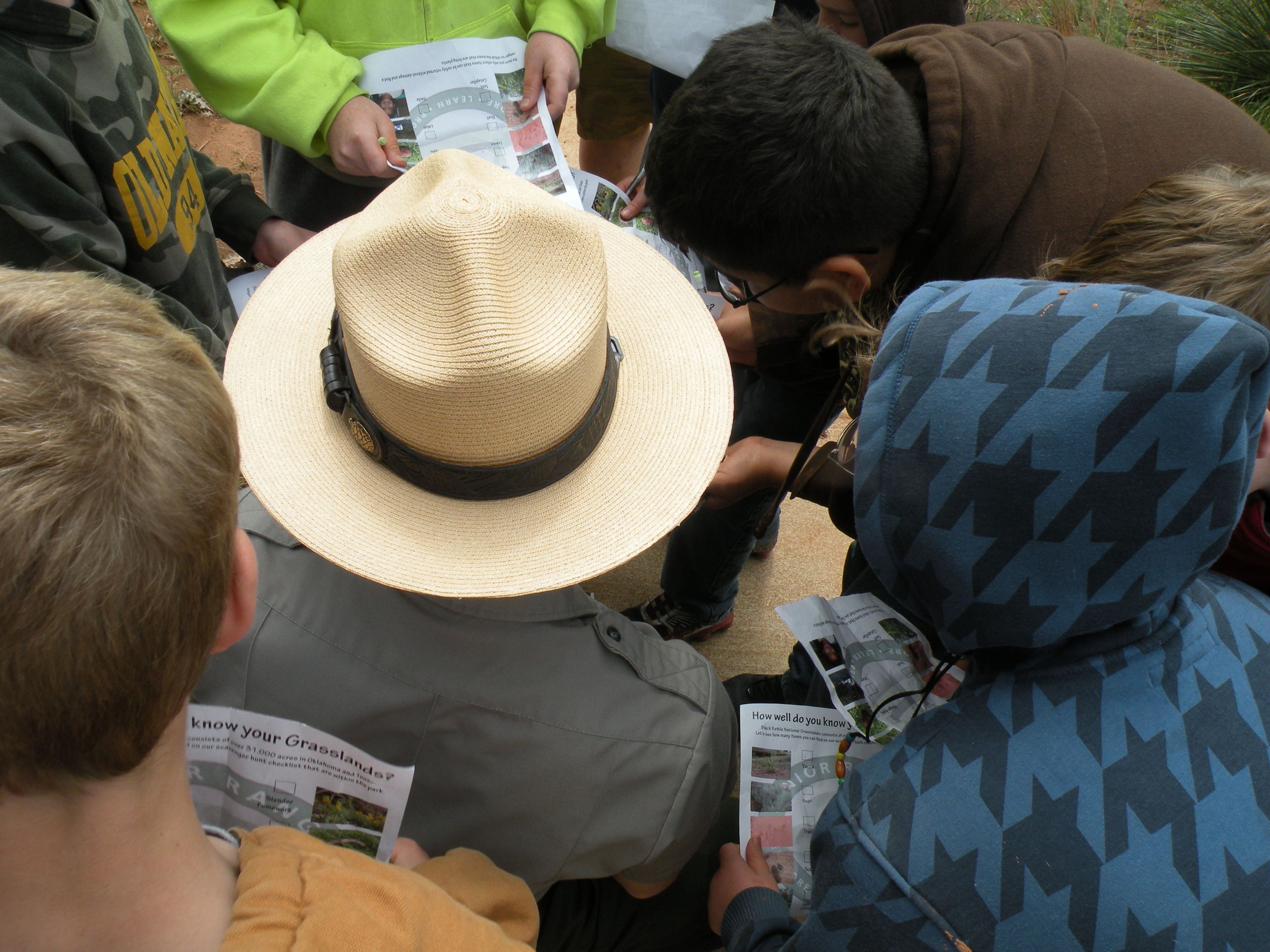 A Park Ranger helps children with their Jr. Ranger books.