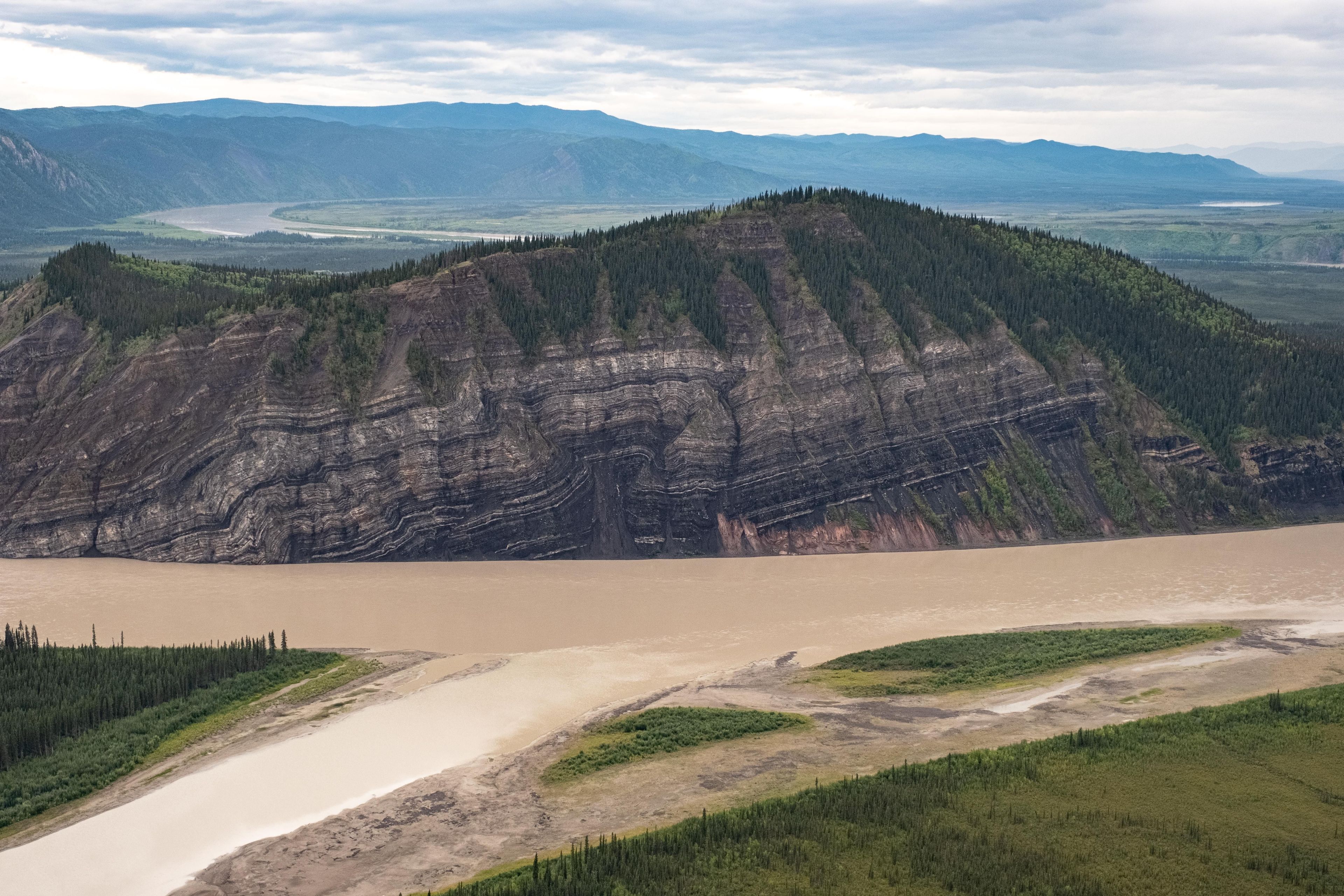 Calico Bluff, showing 4 million years of rock layers, rises above the Yukon River and is one of many bluffs along the 130 miles of river in the preserve