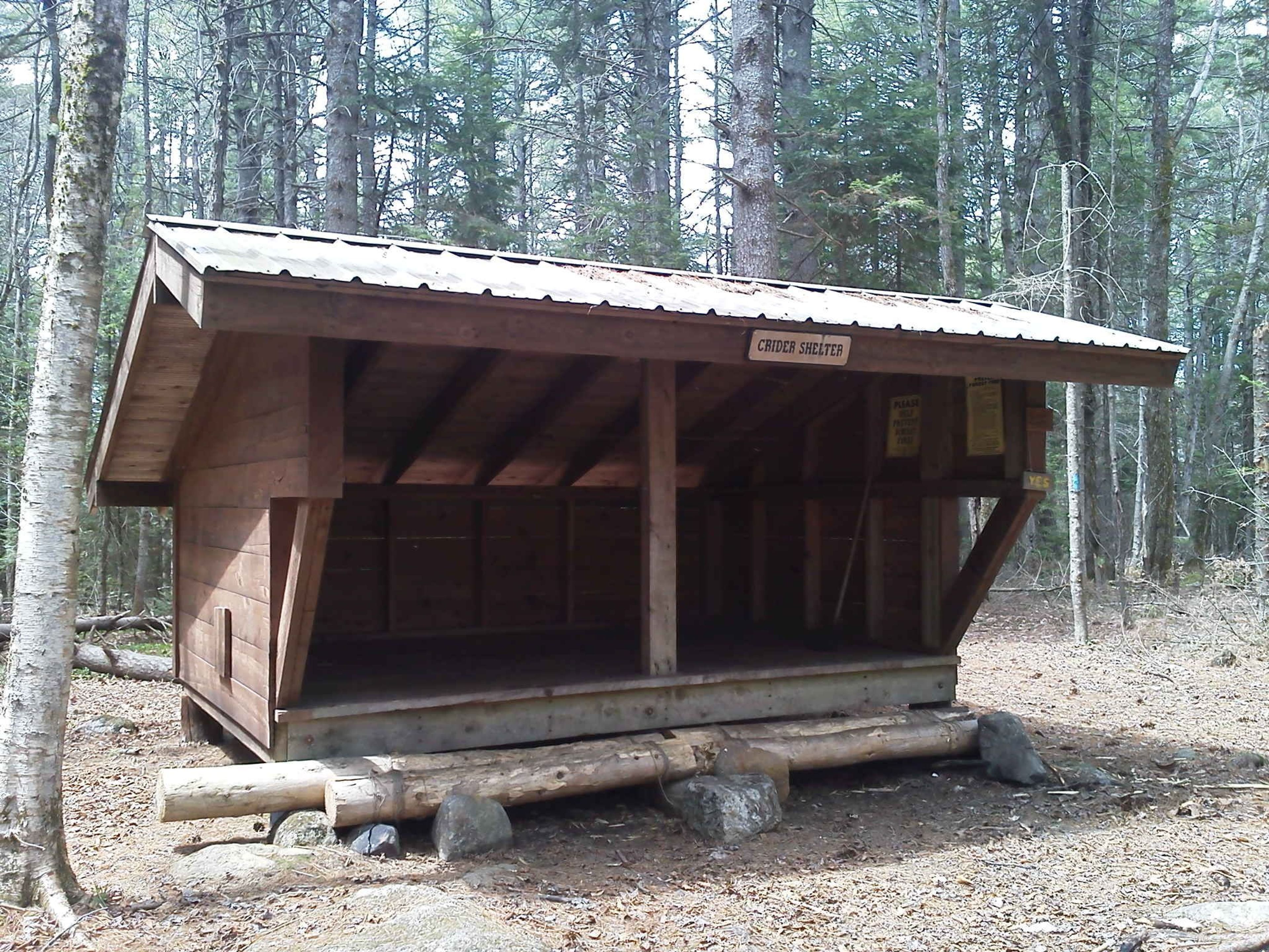 A wooden rest shelter in the trees.