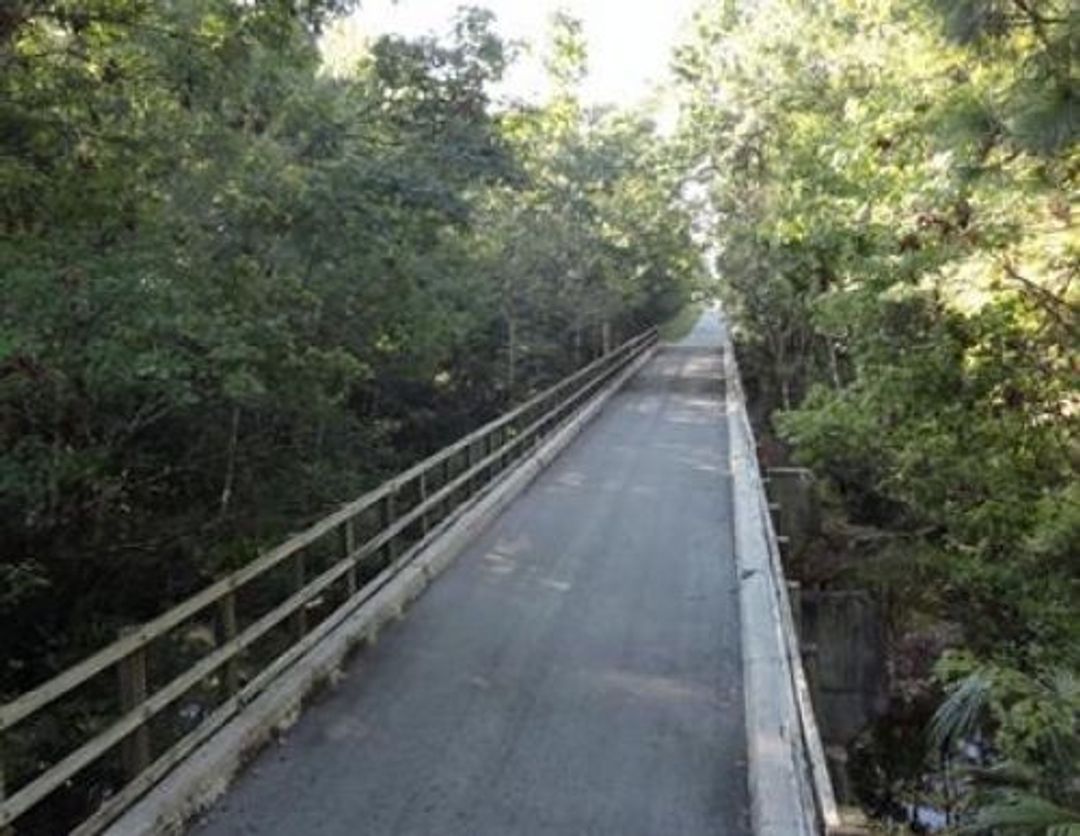 Cyclists take the bridge along this very straight trail.