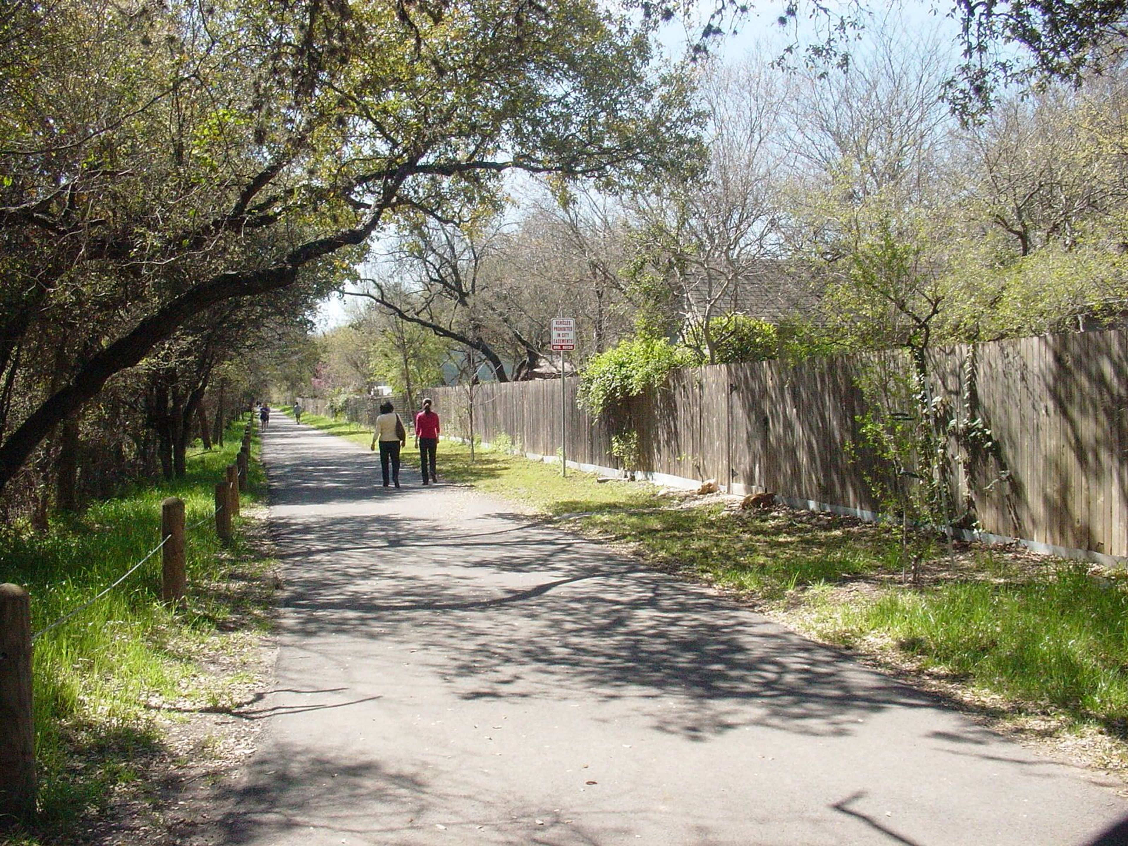 People walking on the Salado Creek Greenway North near Voelcker Trailhead