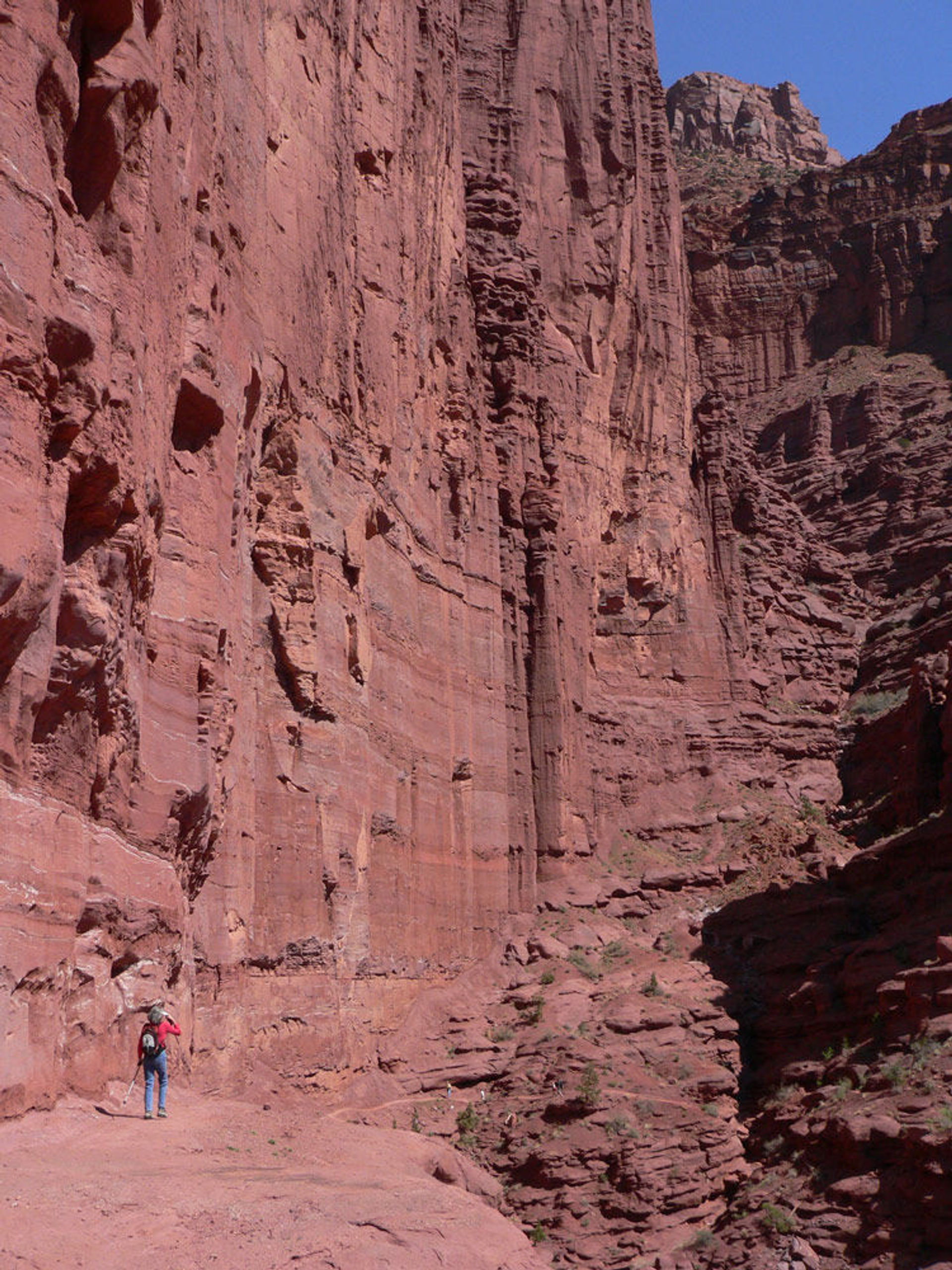 Red rocks wall with hiker for scale. Photo by Stuart Macdonald.