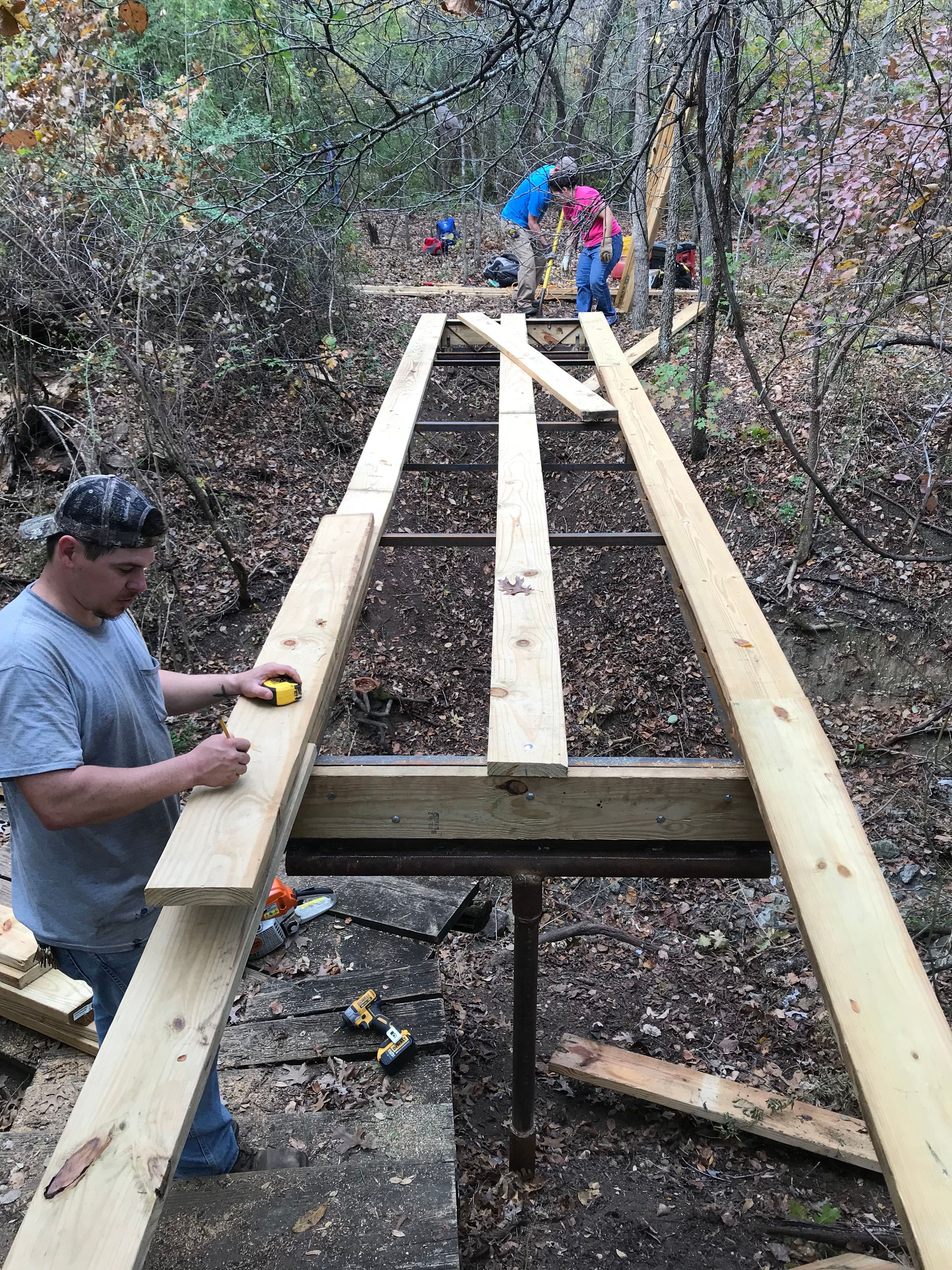 Nic Martinez Refuge Technician prepares to install the deck while volunteers prep the ramp site. Photo by FWNCR Staff.