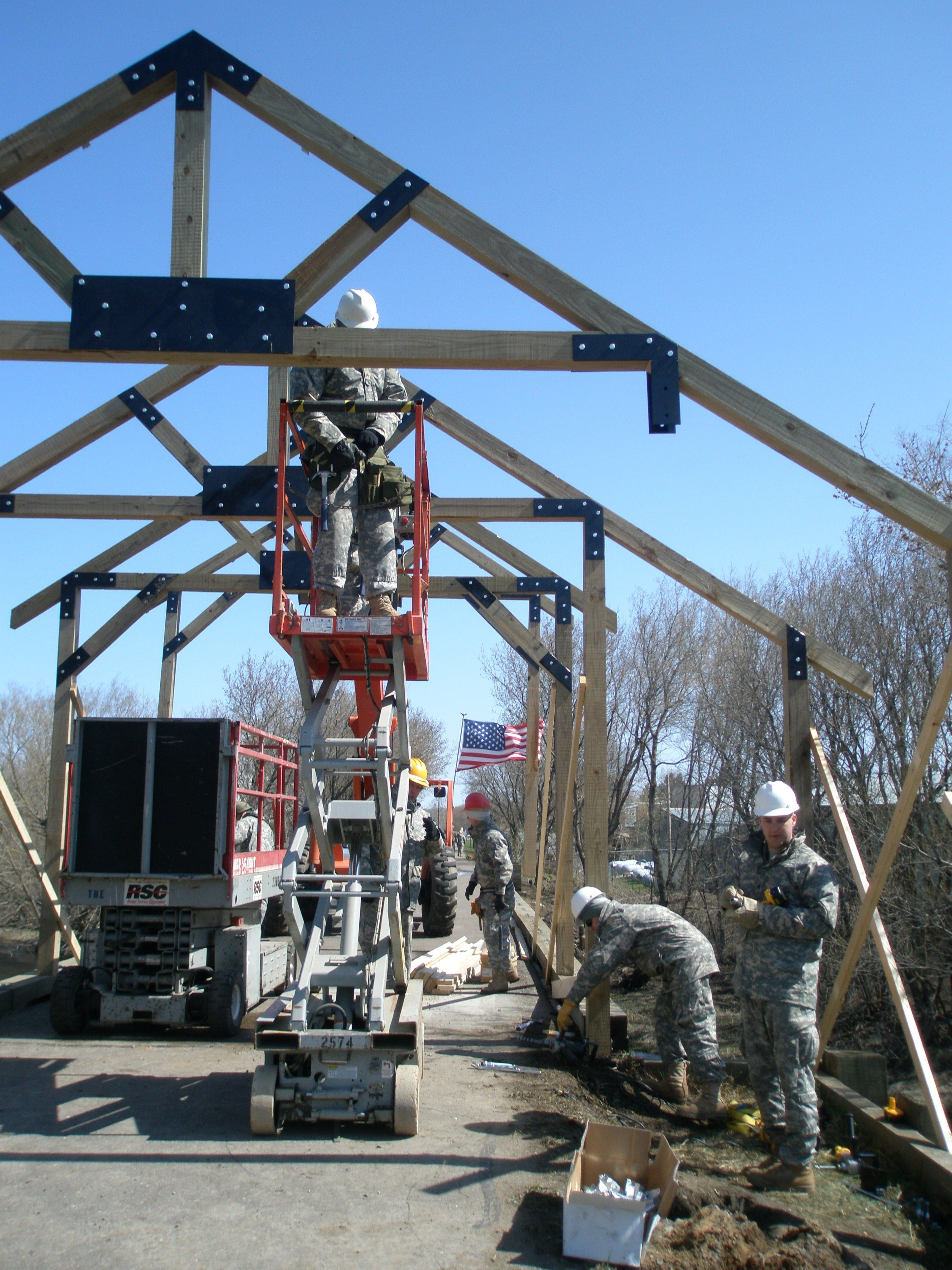 Volunteer Army Reservists attach brackets on bridge. Photo by Chuck Wocken.