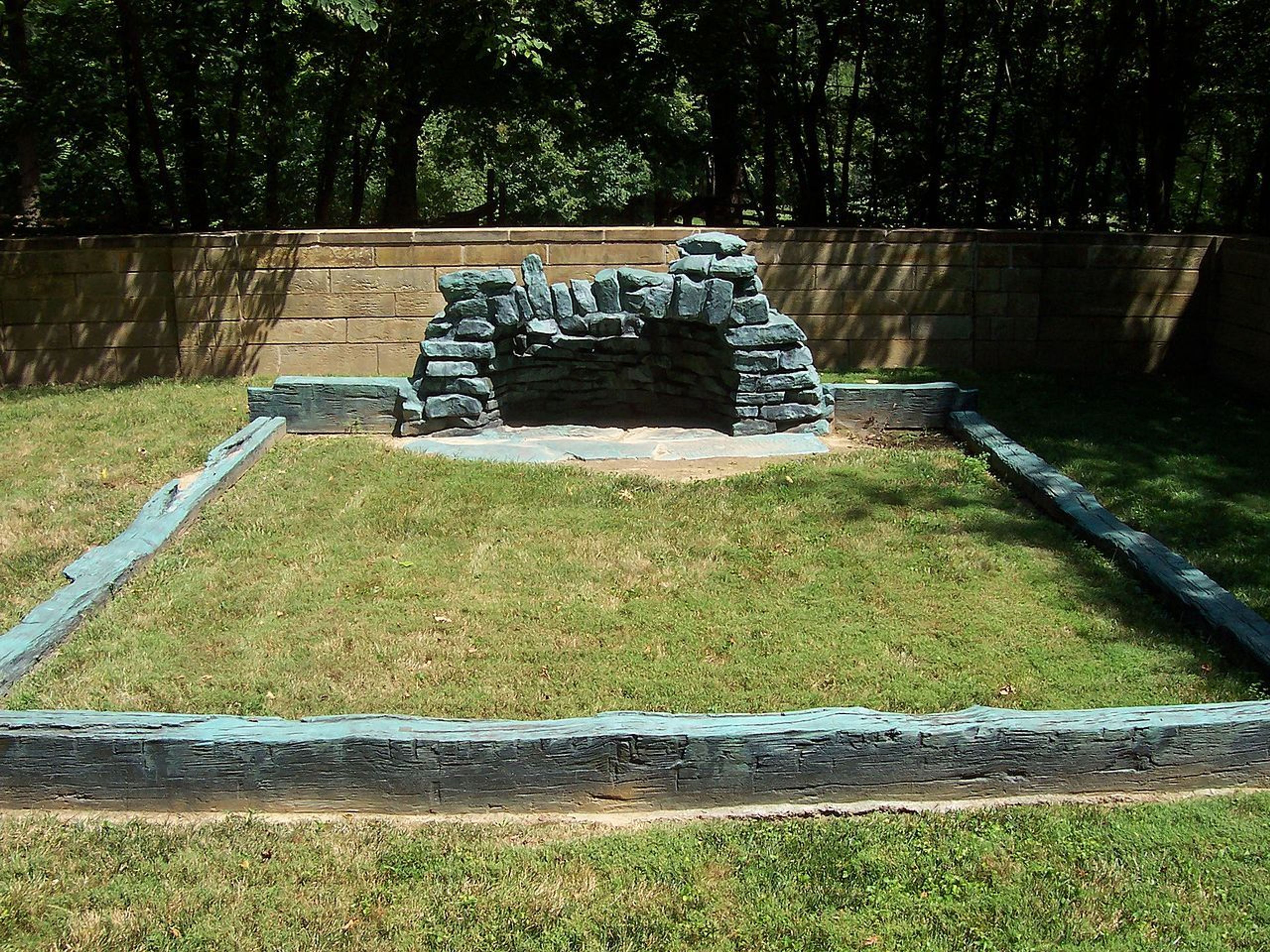 A bronze casting of sill logs and fireplace hearthstones symbolizes a cabin that the Lincolns began building in 1829. Photo by Cool10191/wiki.