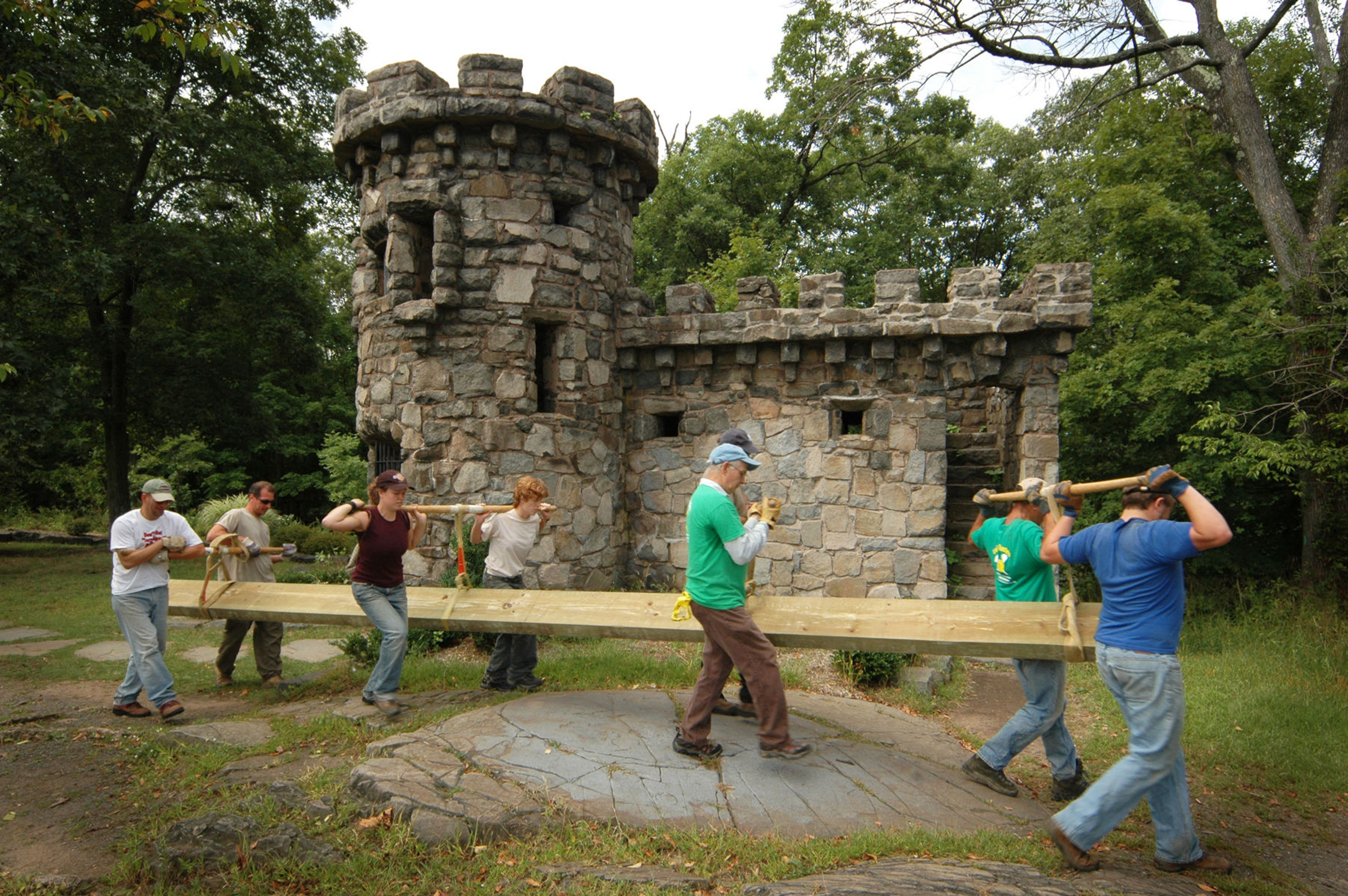 Park employees and NYNJTC volunteers carry a bridge stringer by the Womens Federation Monument. Photo by Anthony Taranto.