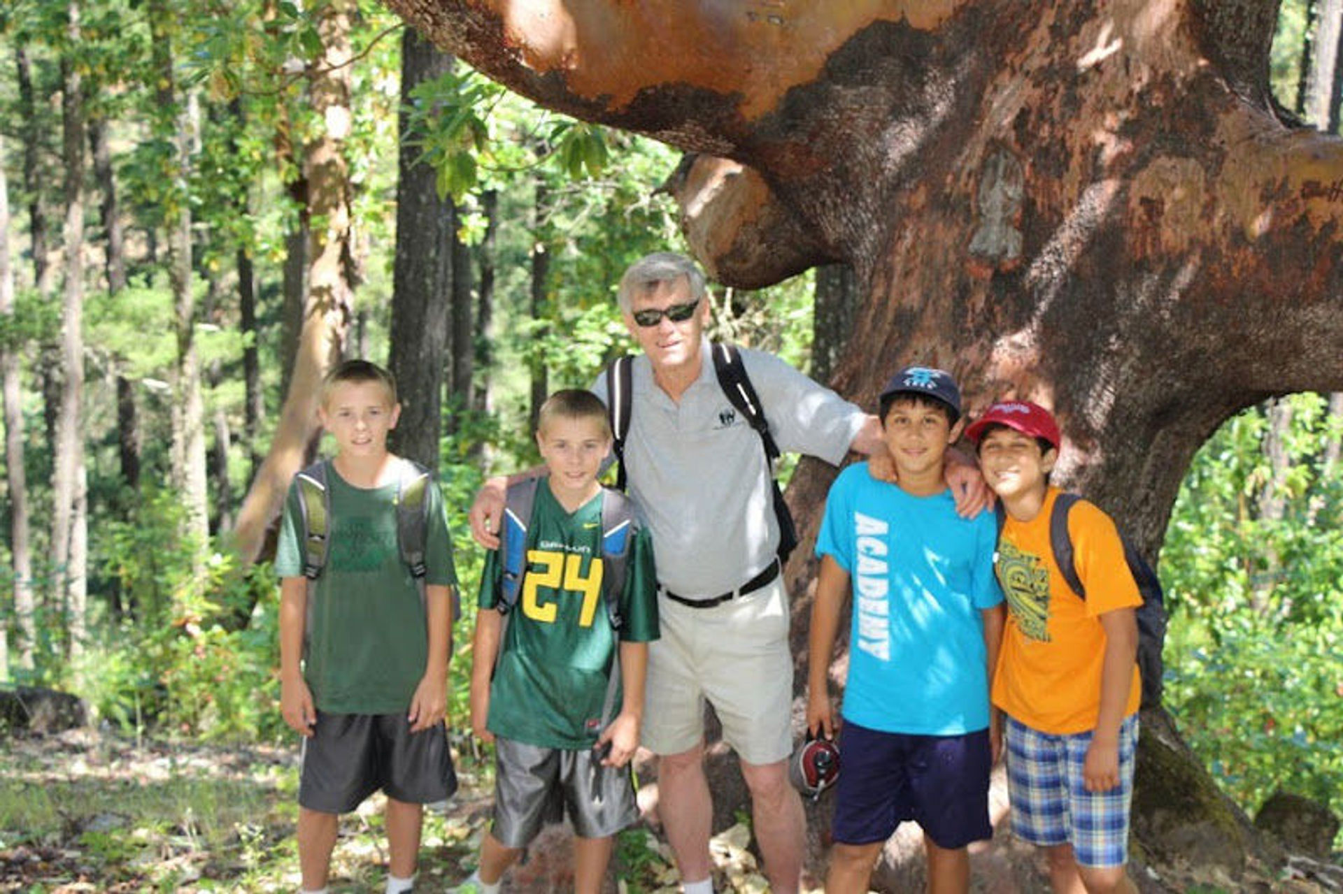 Larry Smith, himself a twin, posing with sixth grade twins in front of Jacksonville's oldest and largest Madrone Tree. Photo by Larry B. Smith.