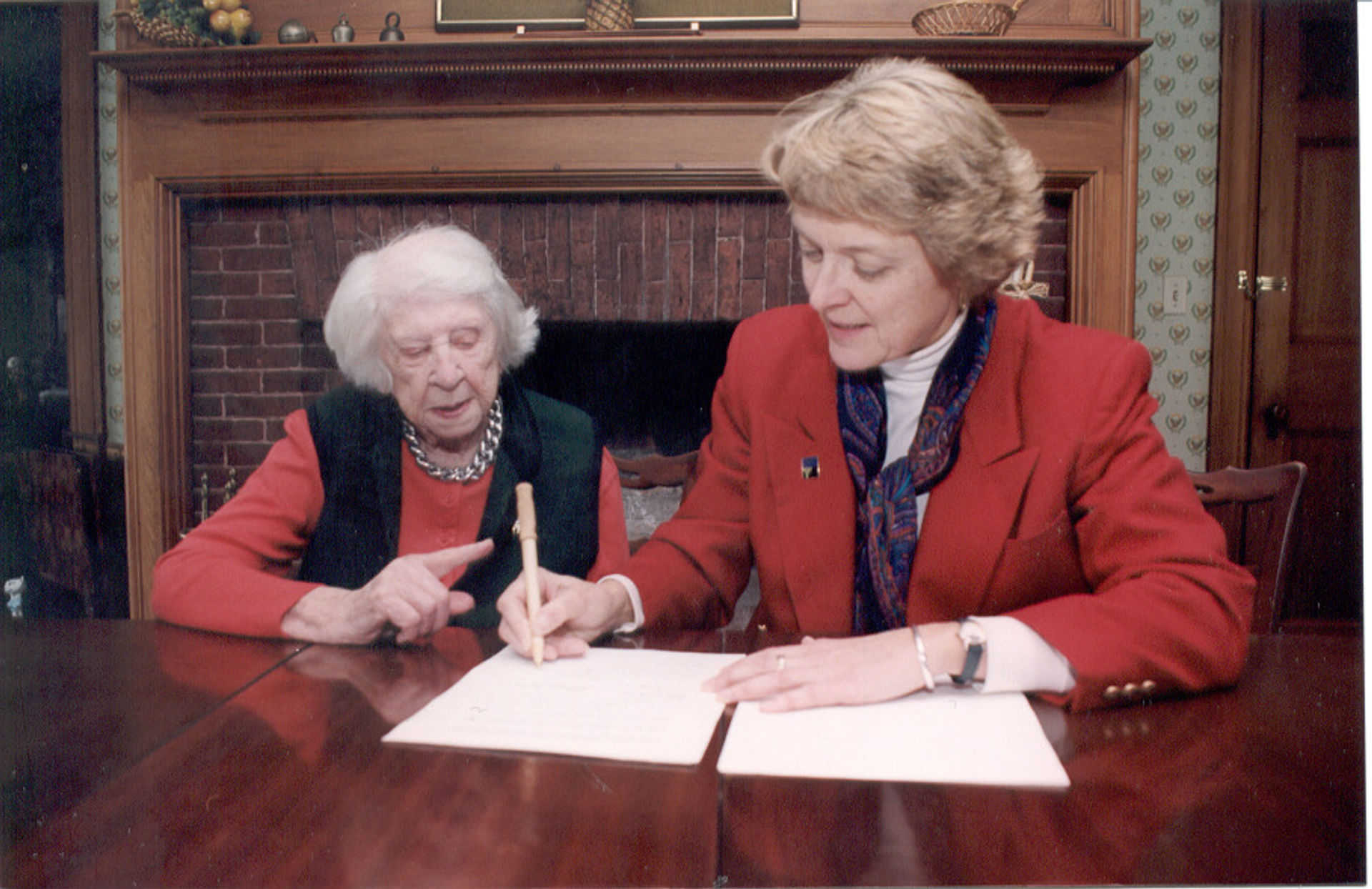 Forest Society former President/Forester Jane Difley signs paperwork with Lillian “Billie” Noel.