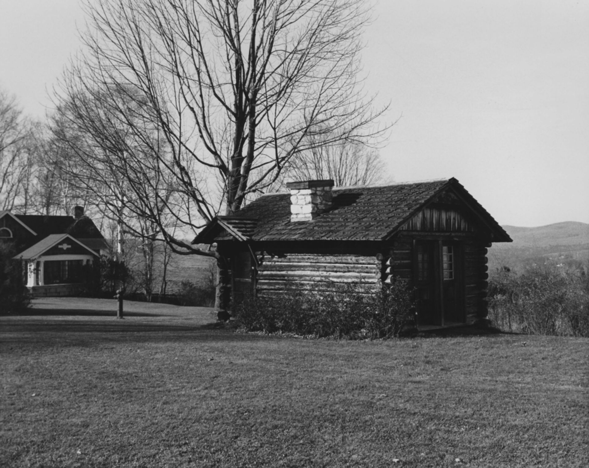 A black and white photo of Fanny's playhouse, a small log cabin.