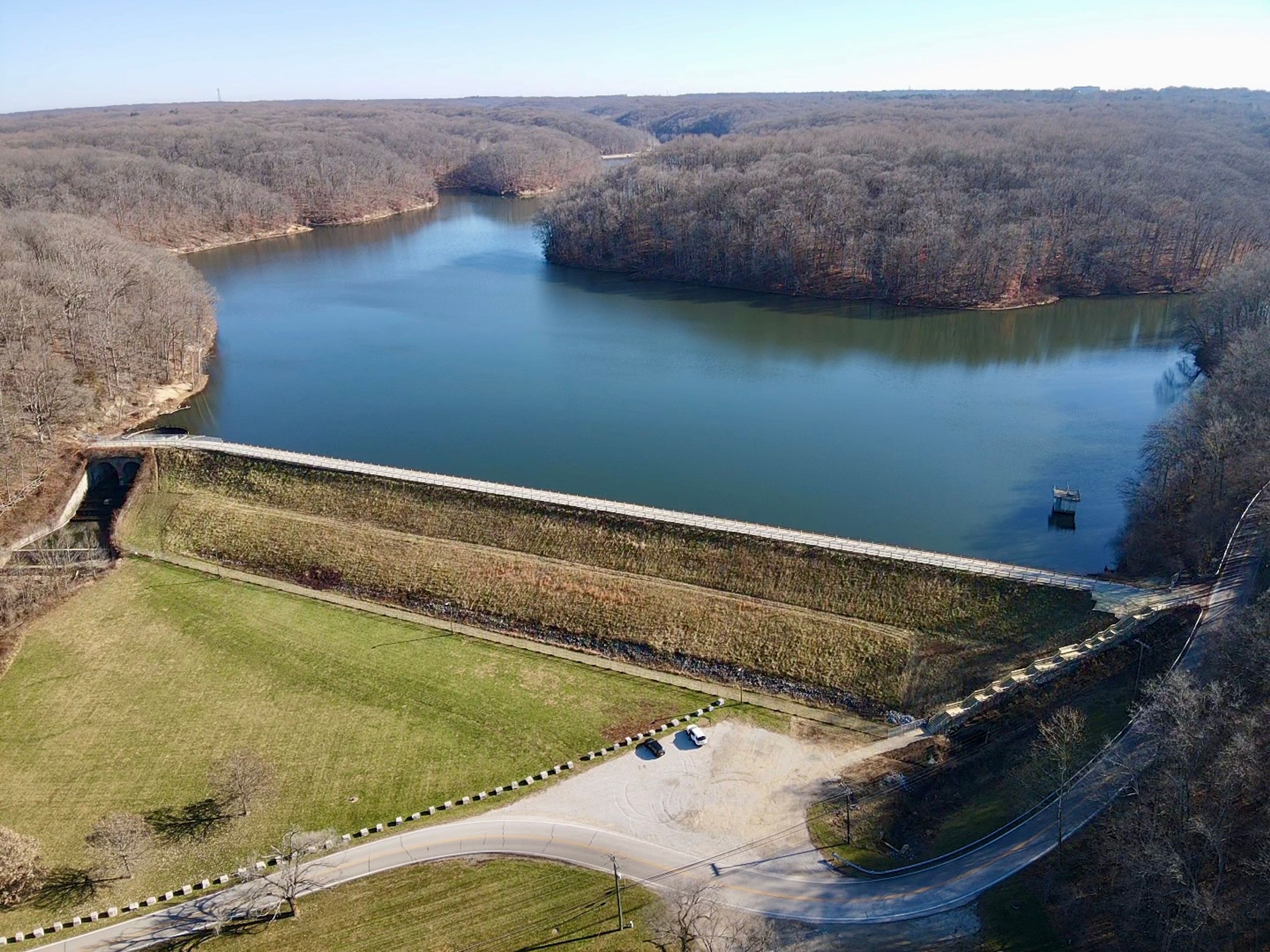 Griffy Lake Dam Crossing and gravel parking lot with a wooden staircase to access South Shore Trails.