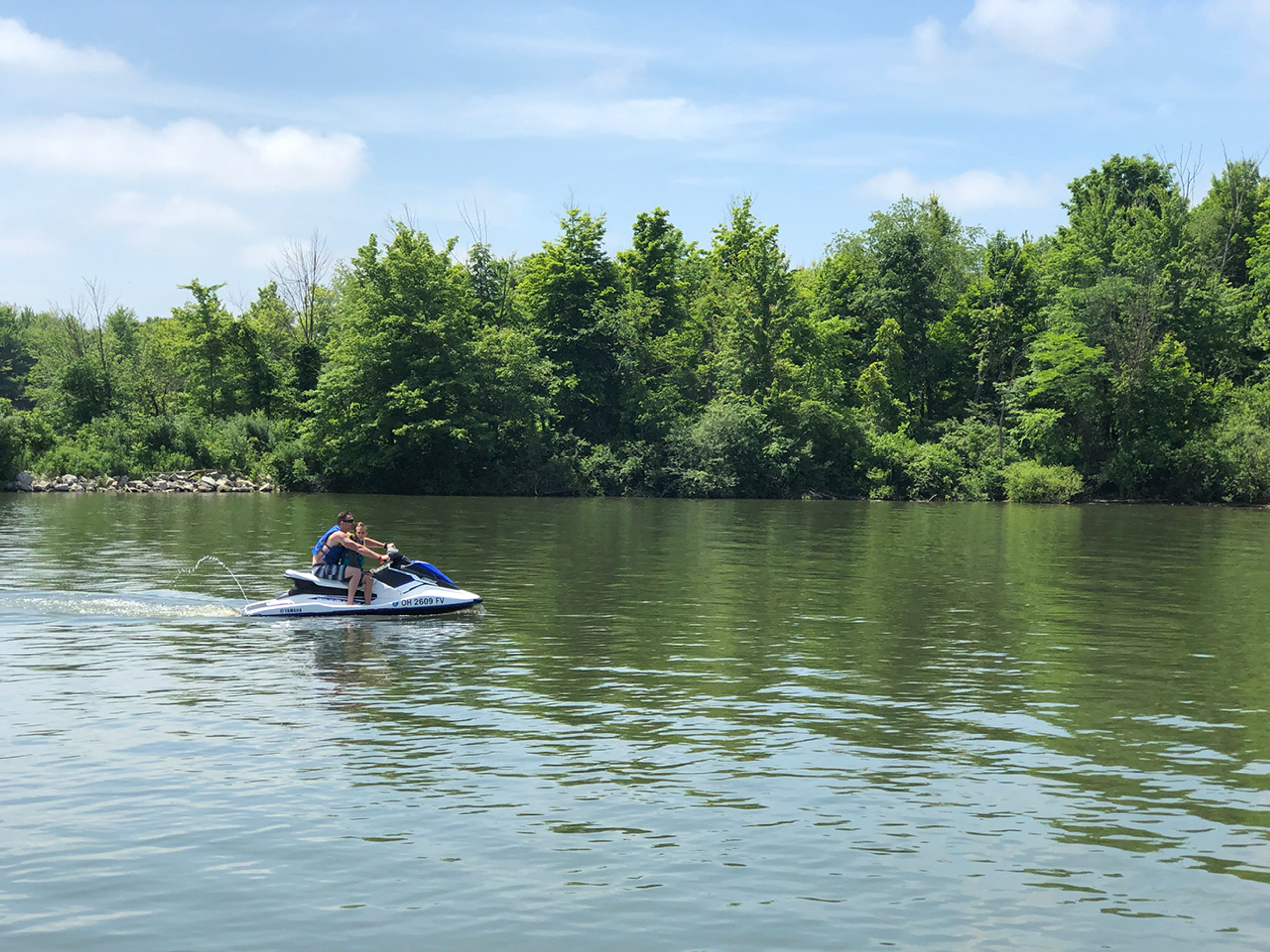 Two people leisurely riding a jet-ski on a sunny afternoon at Alum Creek State Park.