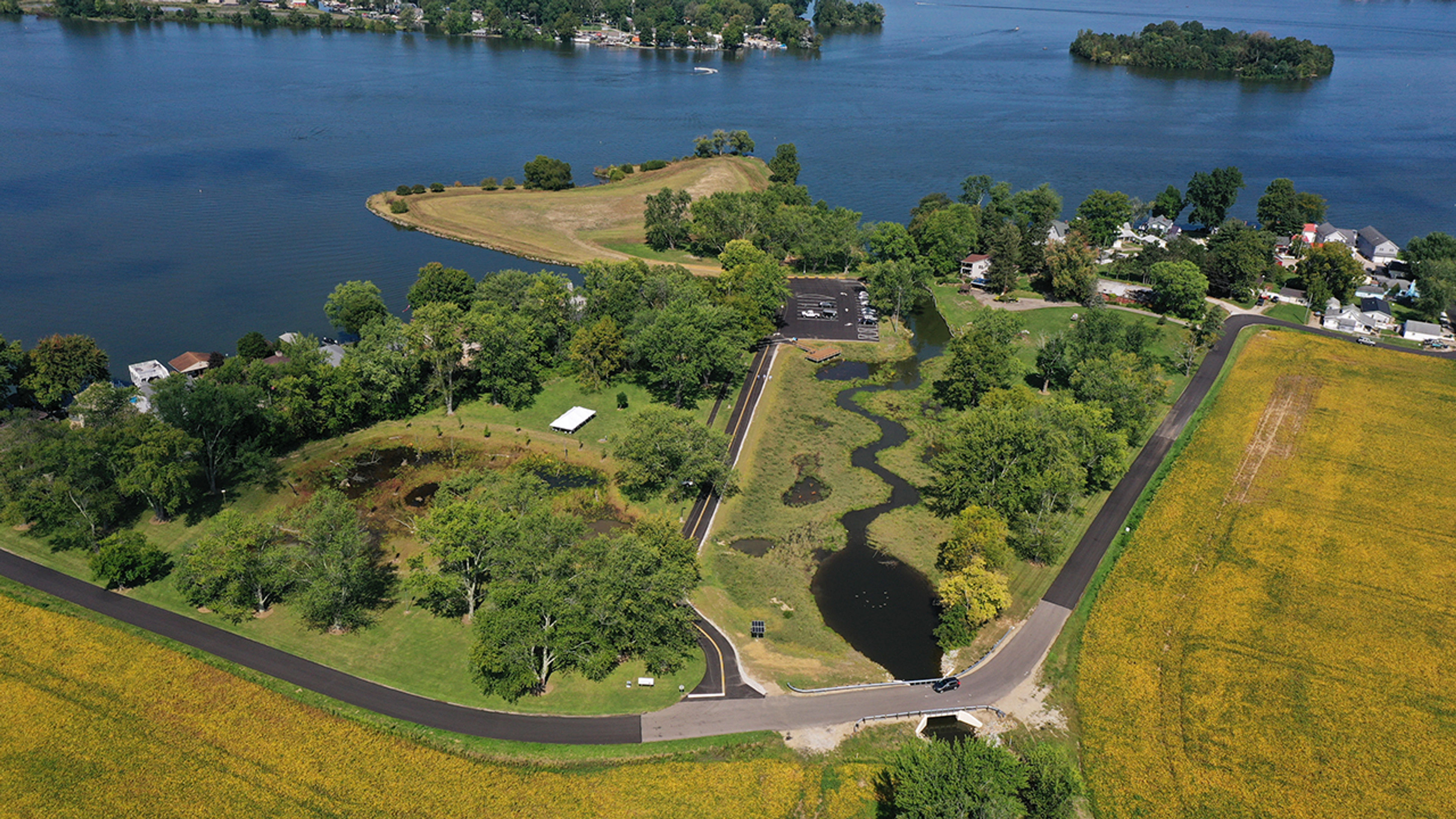 An aerial view of a wetland surrounded by trees and a lake behind at Buckeye Lake State Park.