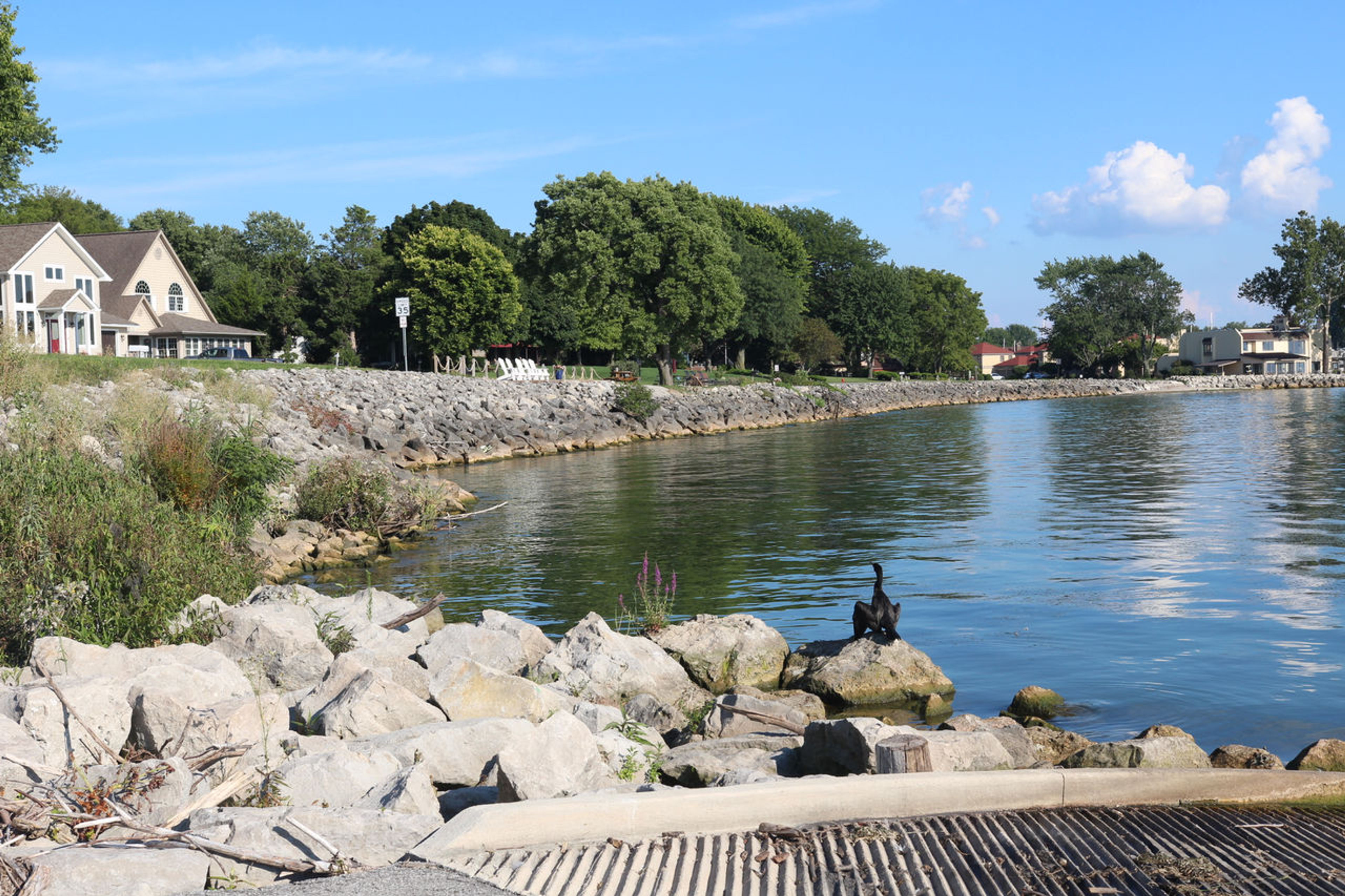 Rocky shoreline of Lake Erie with a home in the background at Catawba Island State Park.