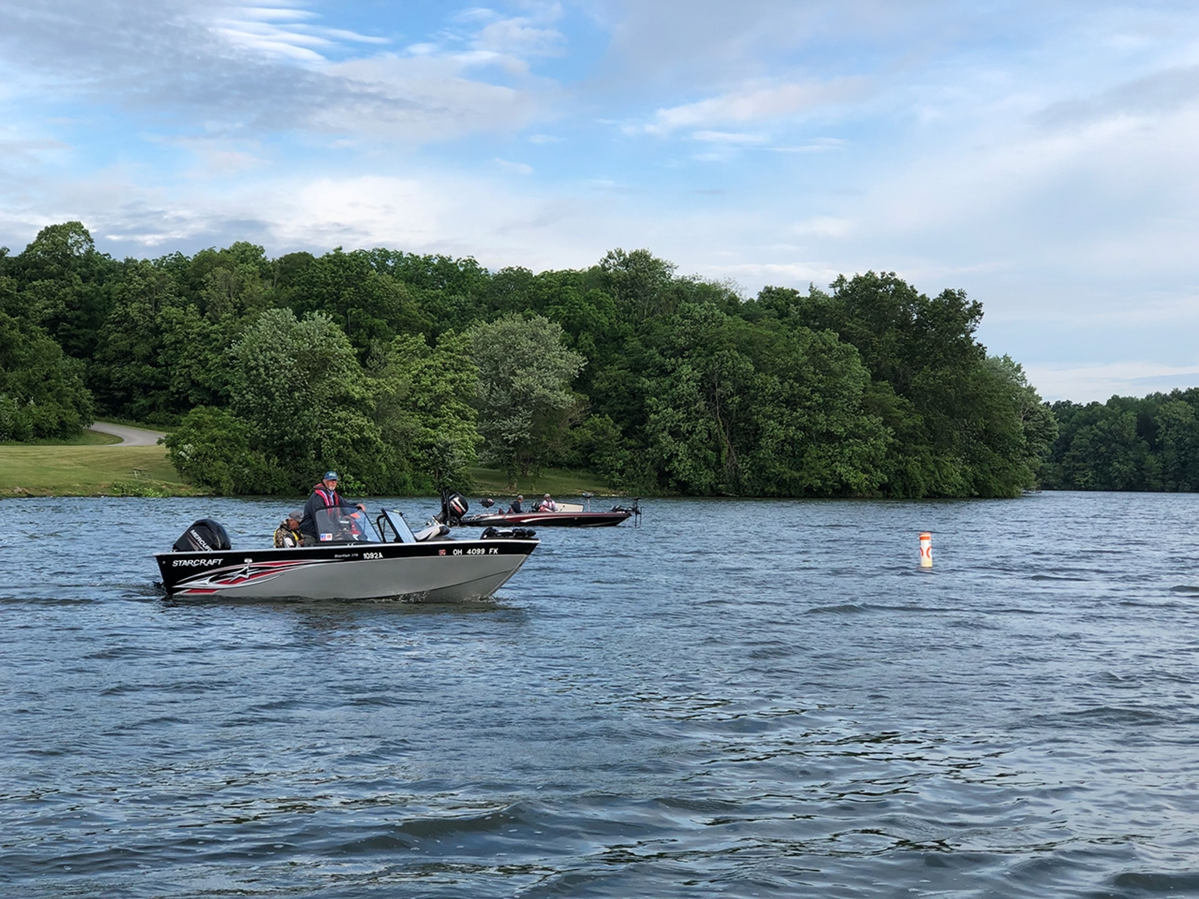 Two boats in the water in front of trees at Cowan Lake State Park.