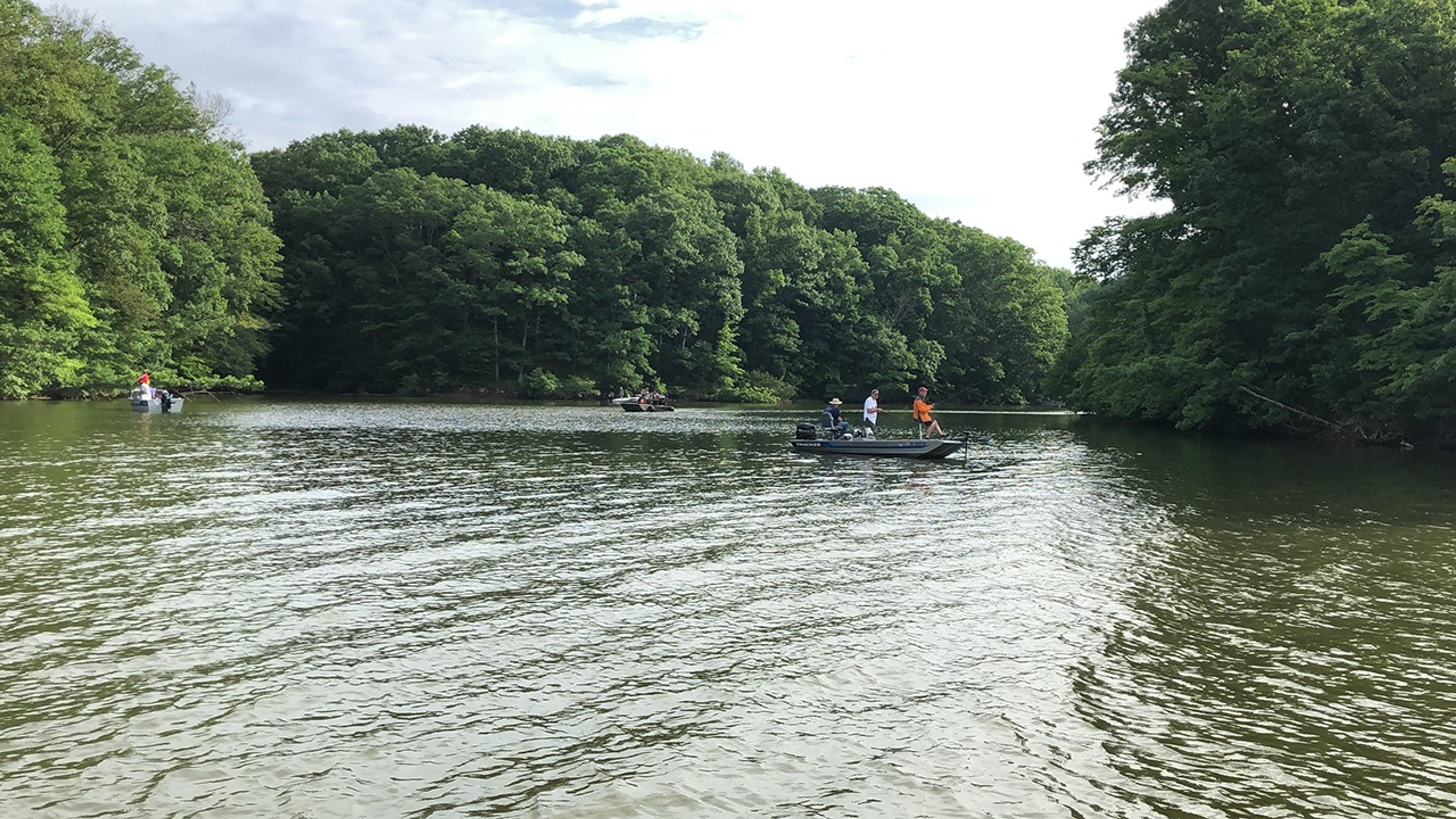 Three boats with people fishing in the water at Cowan Lake State Park.