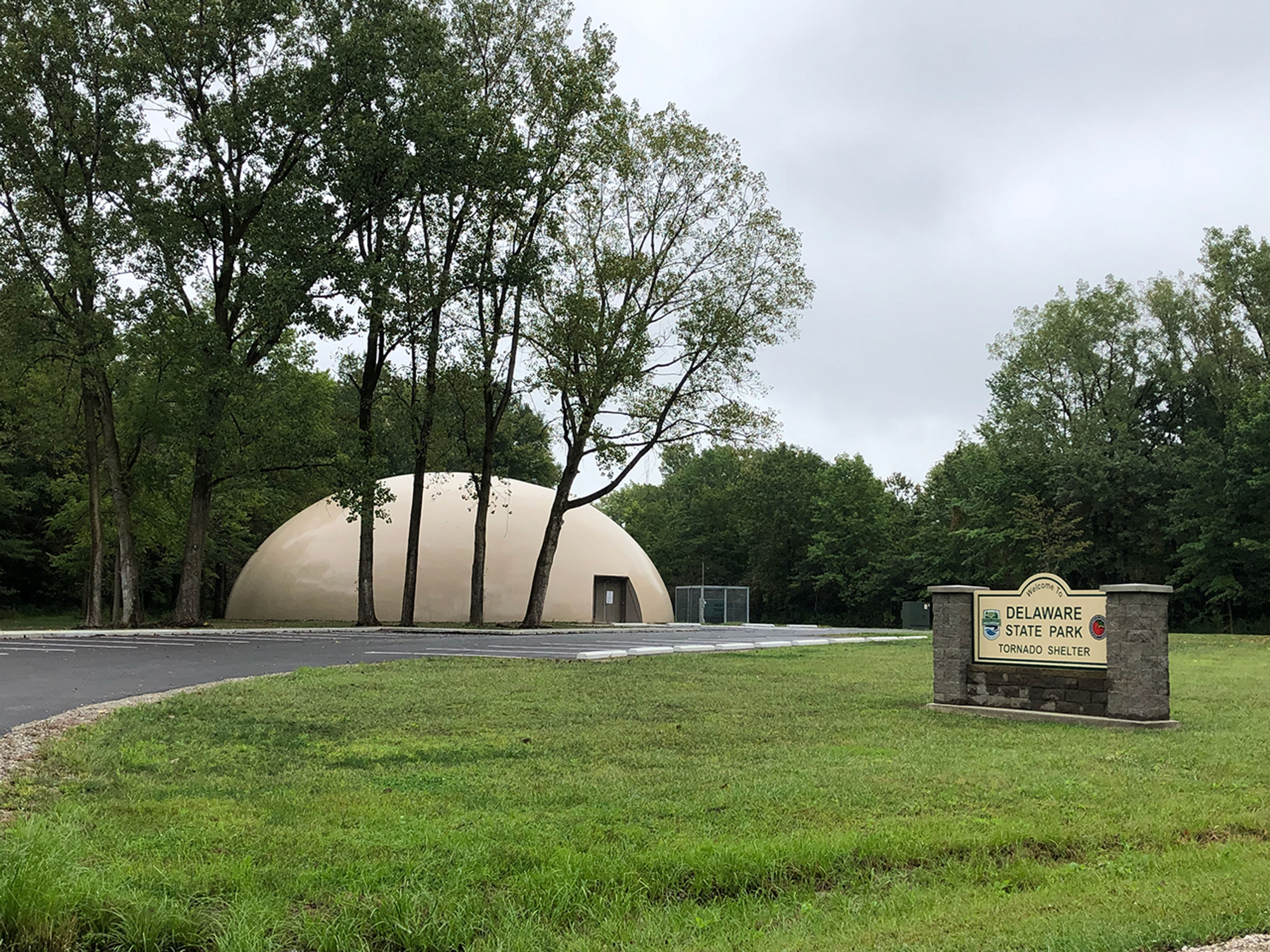 View of the Delaware State Park Tornado Shelter building behind some trees.