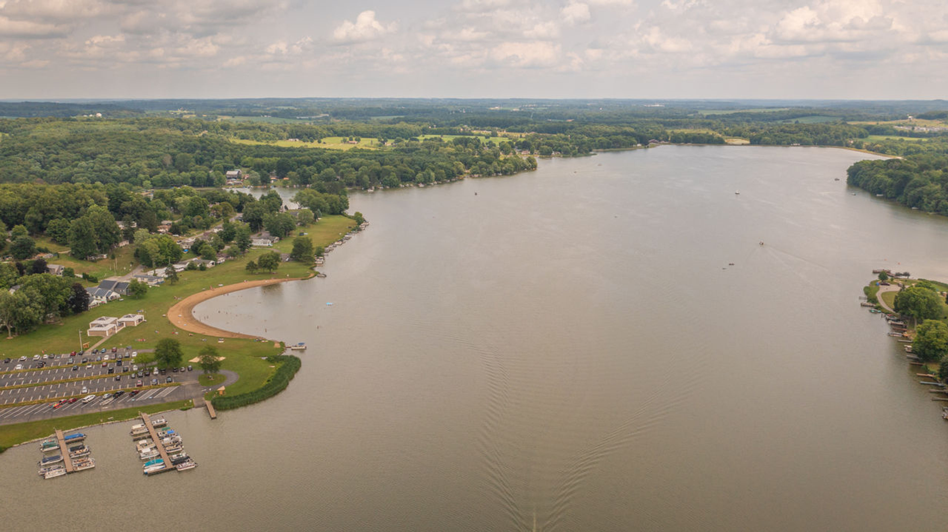 Aerial view of a lake with a view of the marina and surrounding trees at Guilford Lake State Park