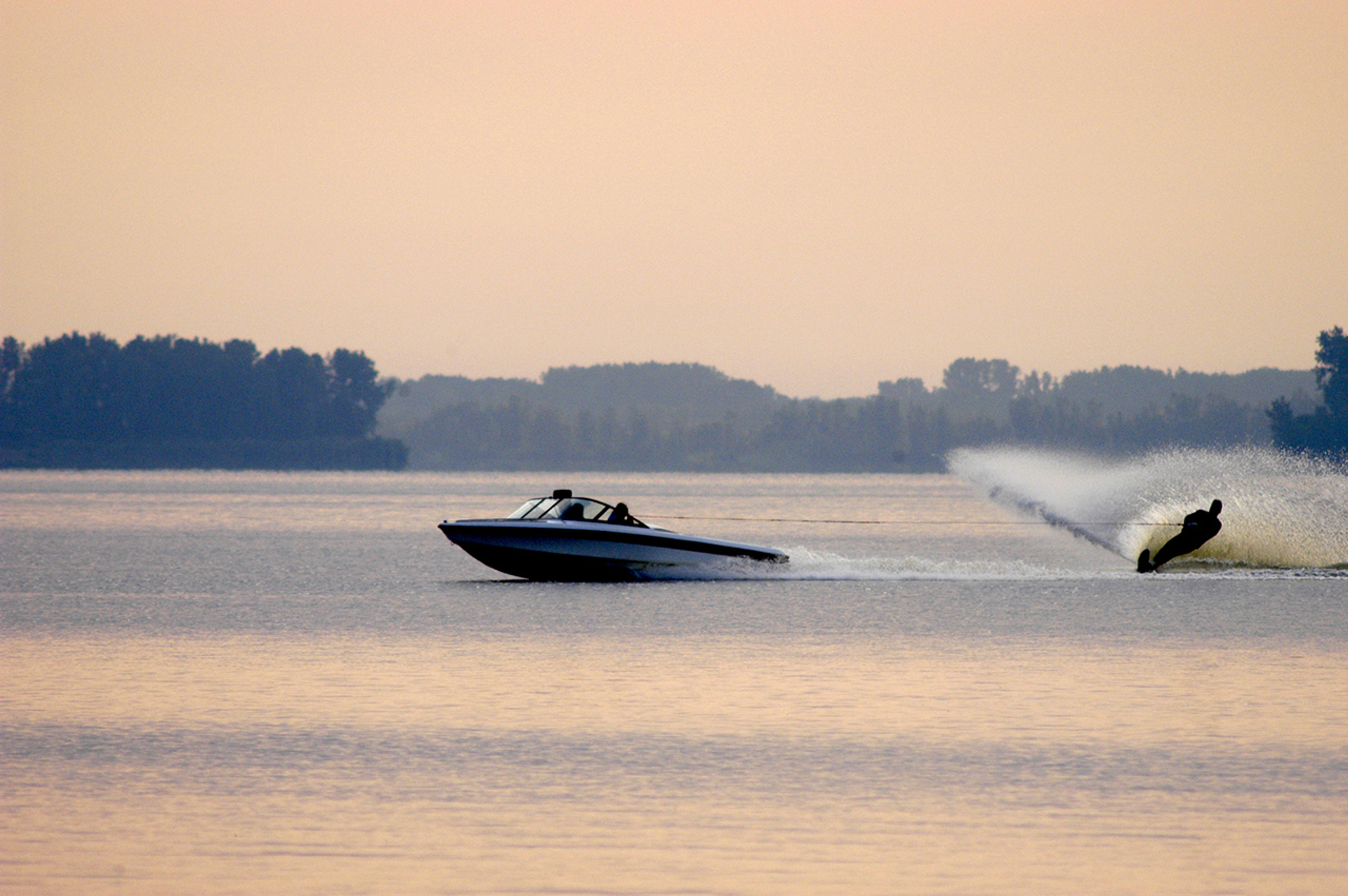 A speed boat and a person water skiing behind on a lake at Indian Lake State Park