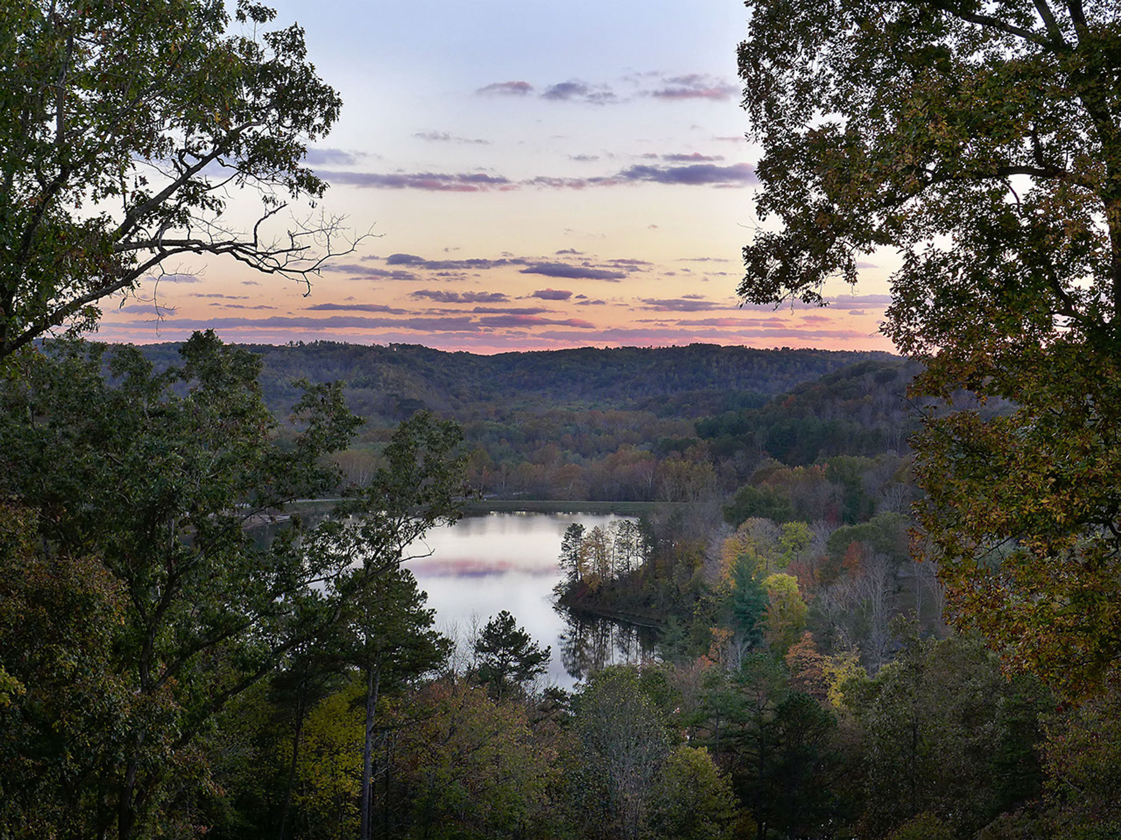 A lake surrounded by trees at dusk at Lake Hope State Park.